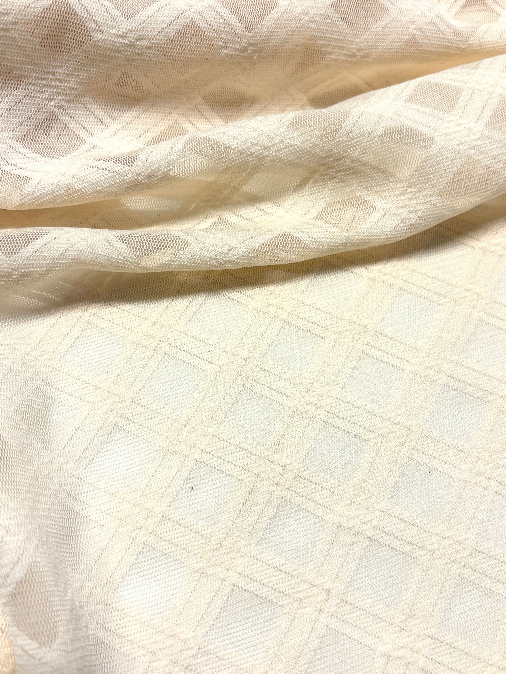 Close-up of crossover mesh fabric in cream, soft texture visible 