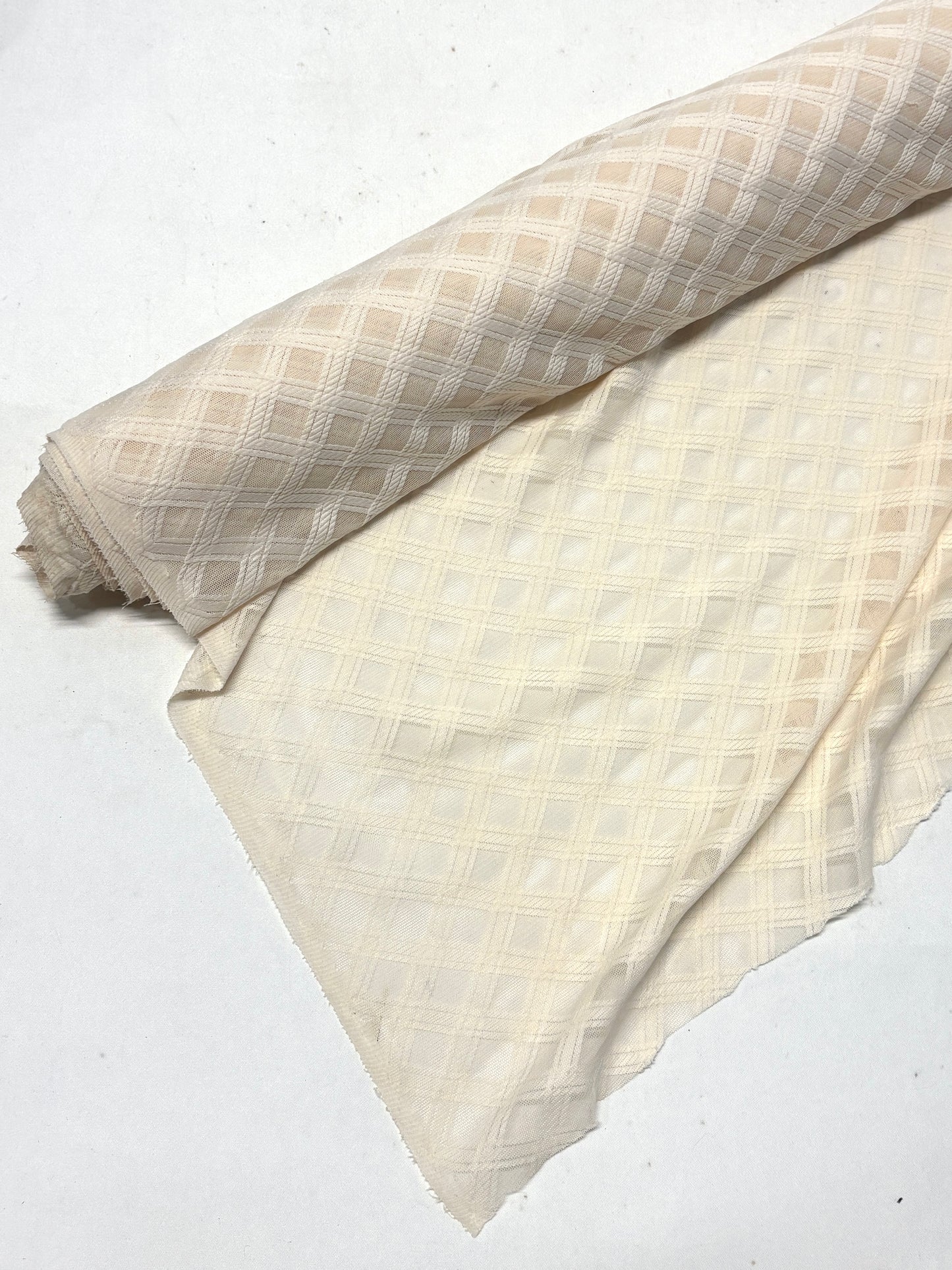 Roll of crossover mesh fabric in cream, soft texture visible 
