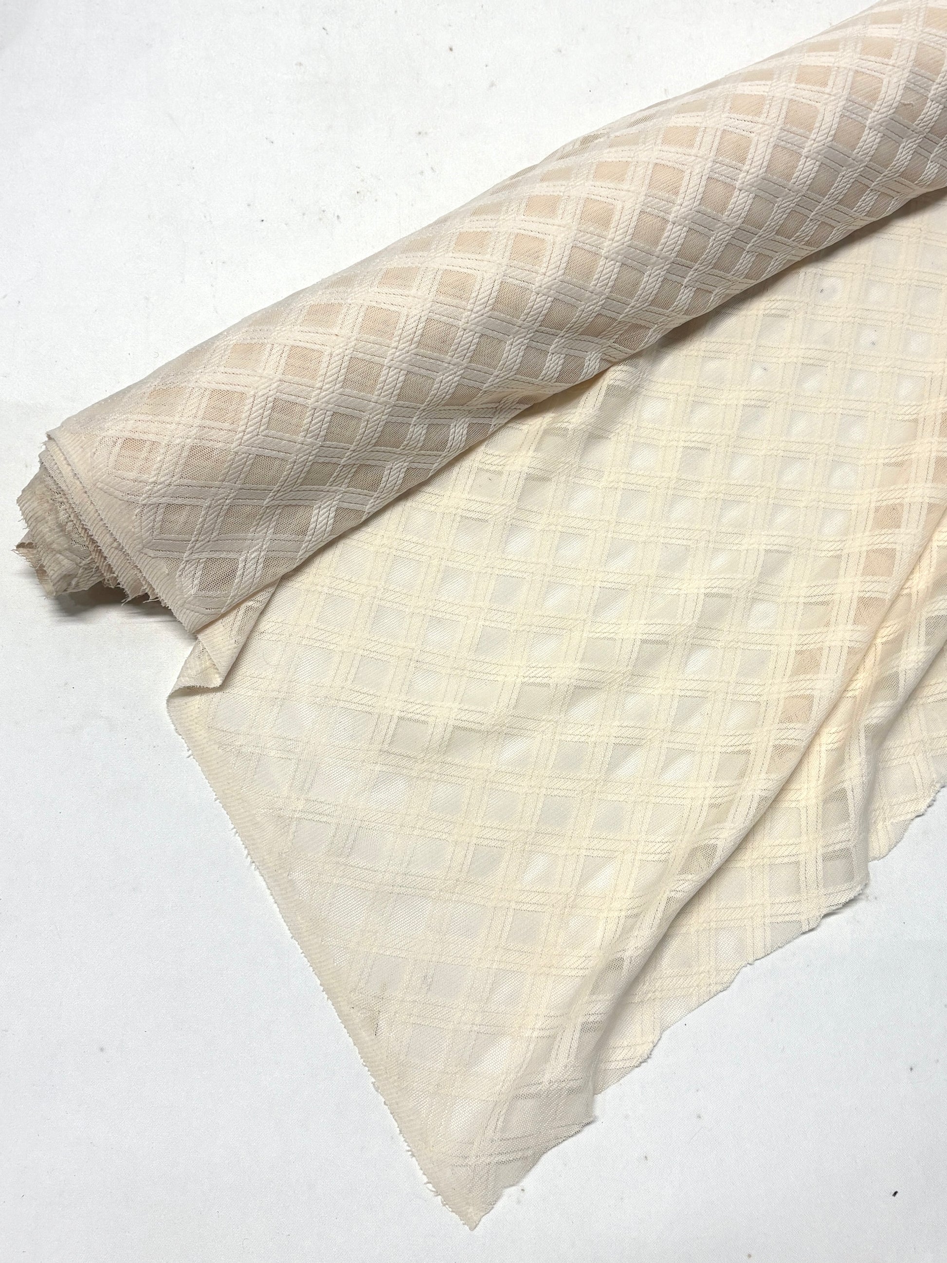 Roll of crossover mesh fabric in cream, soft texture visible 