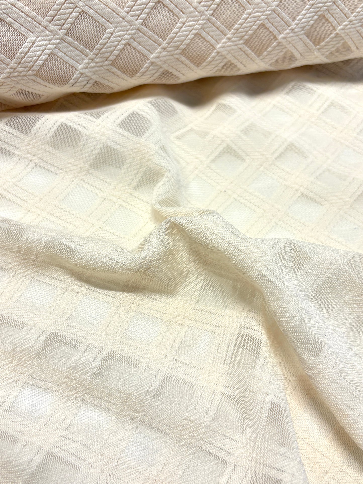 Close-up of crossover mesh fabric in cream, soft texture visible 