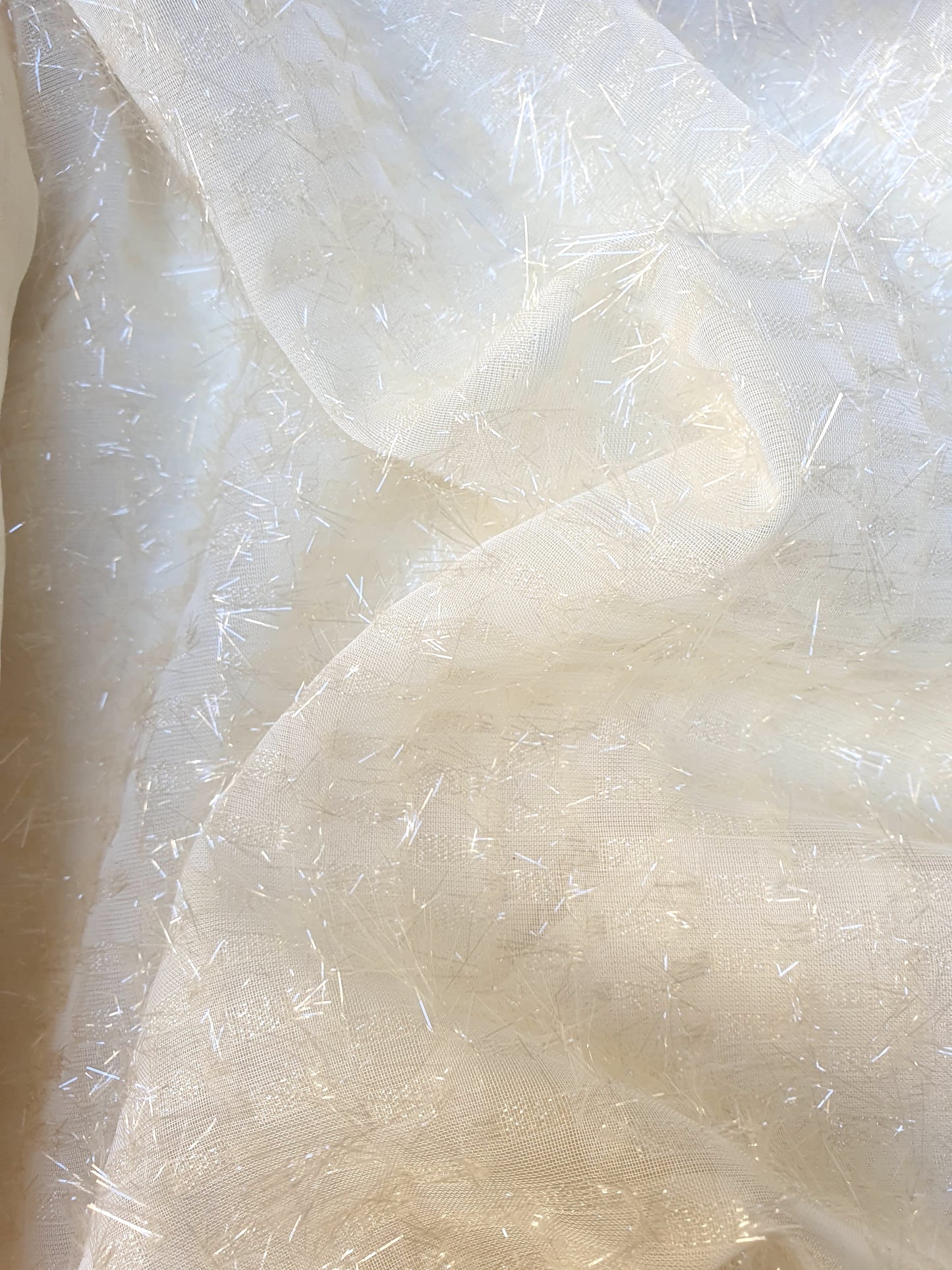 Close-up of sparkly embroidered fabric in  cream