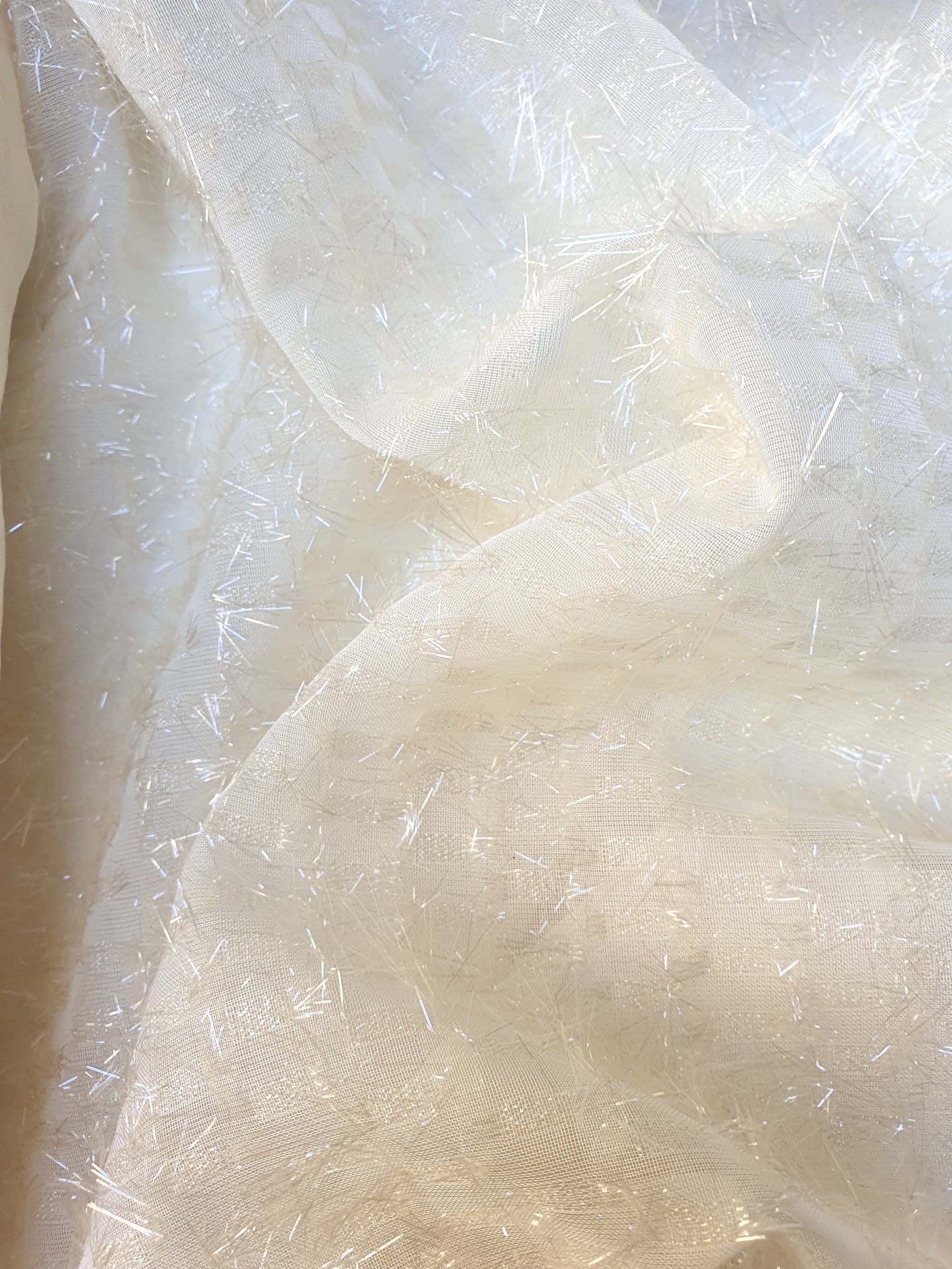 Close-up of sparkly embroidered fabric in  cream