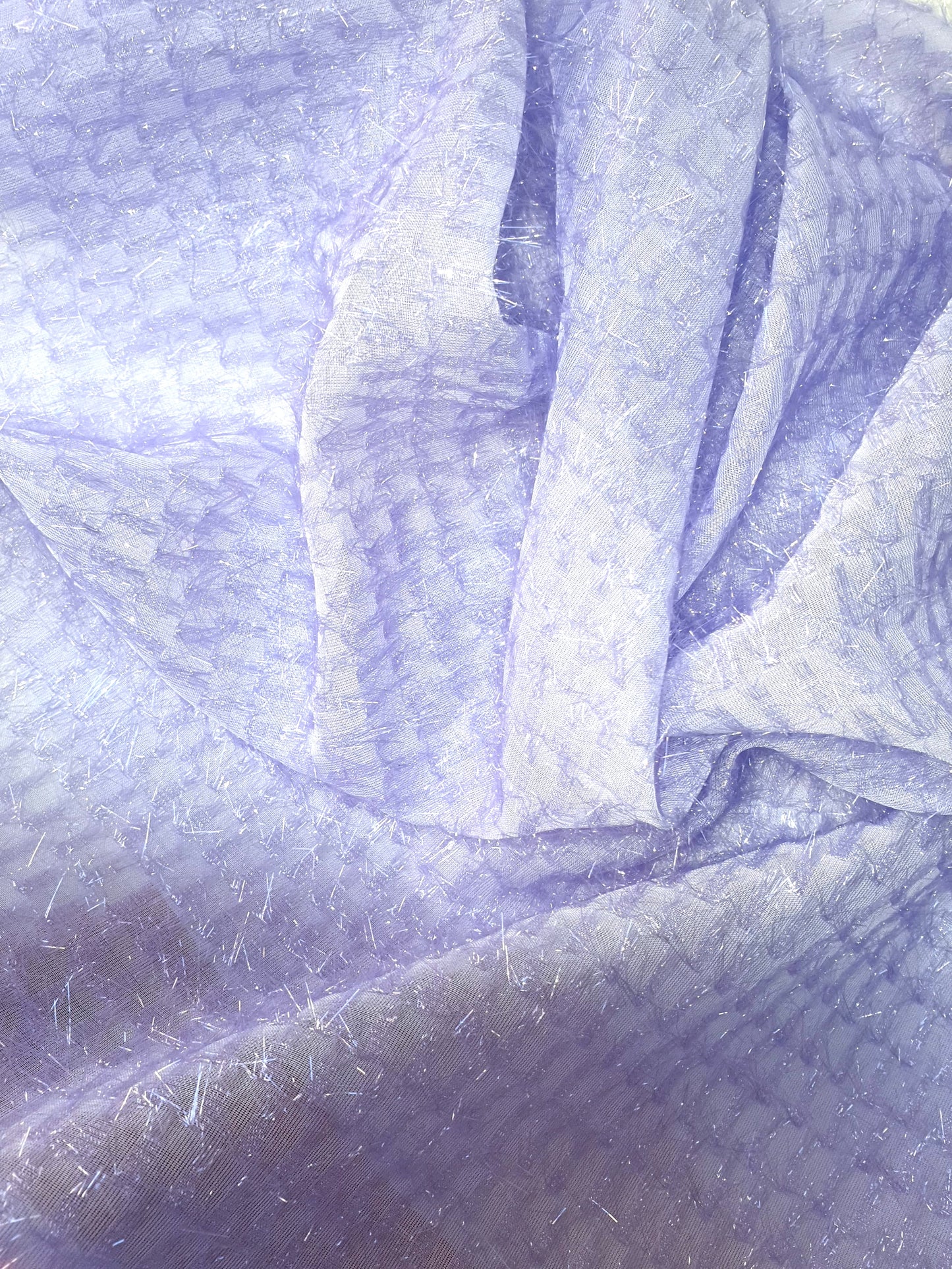 Close-up of sparkly embroidered fabric in lilac