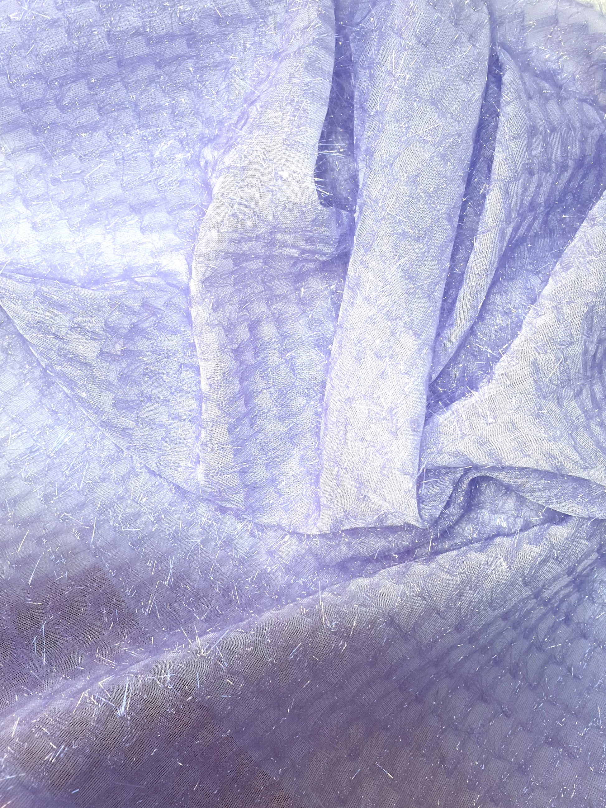 Close-up of sparkly embroidered fabric in lilac