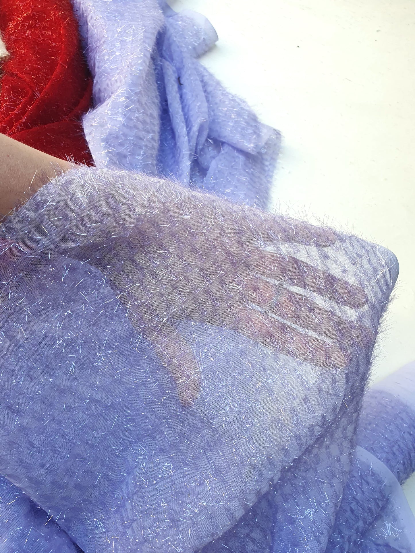 Close-up of sparkly embroidered fabric in  lilac 