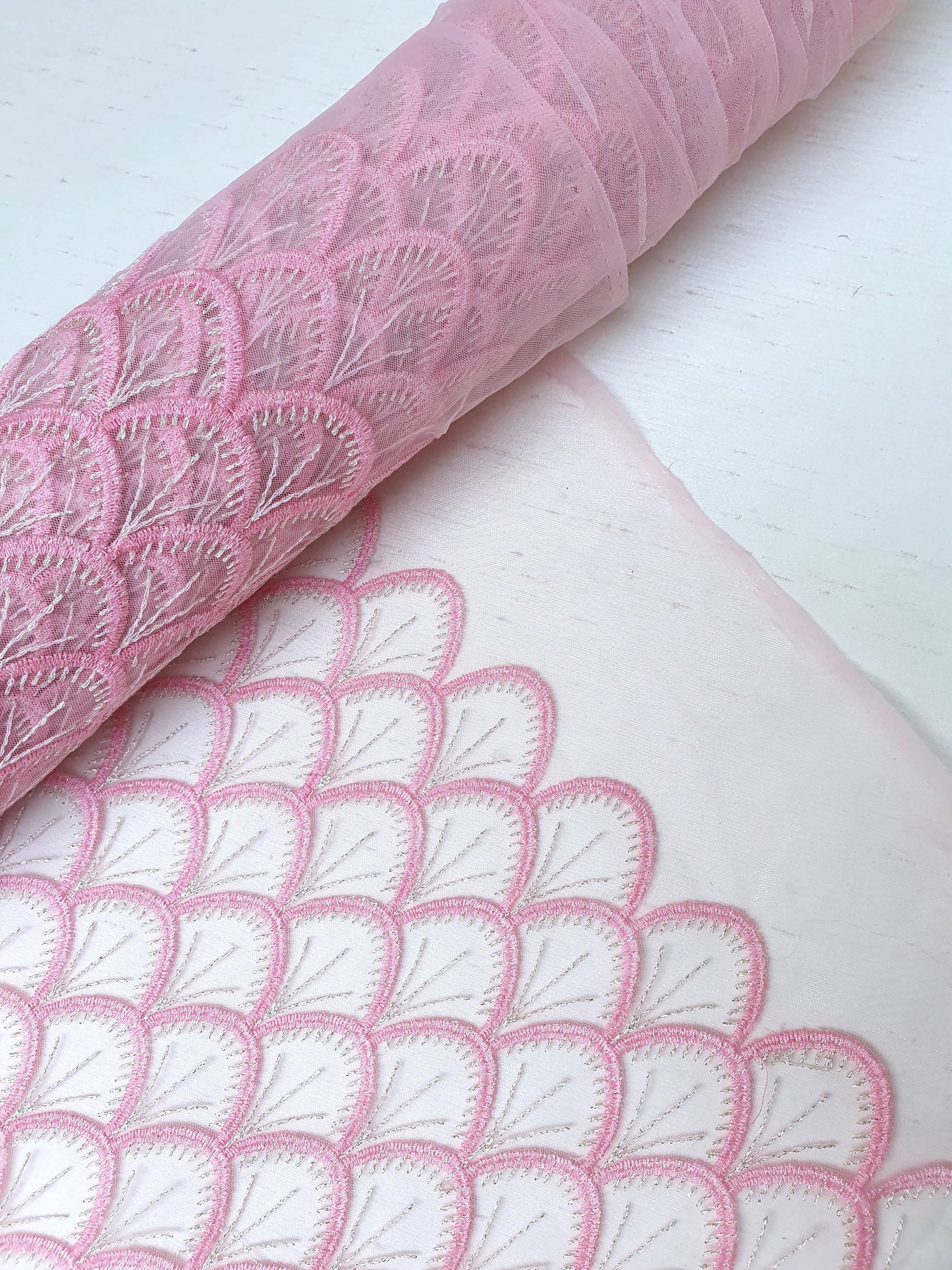 Roll of embroidery lace fabric in pink 