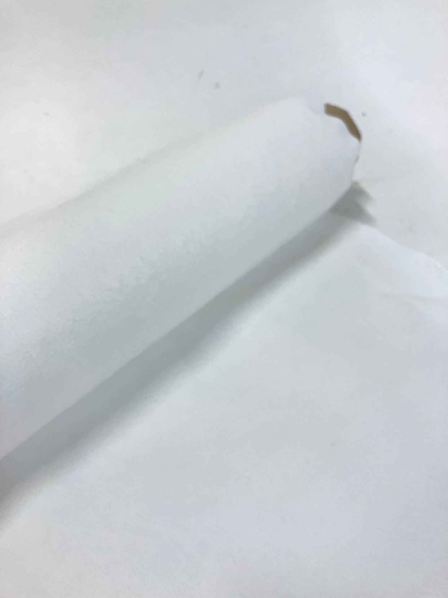 Roll of cellulosic felted fabric in white