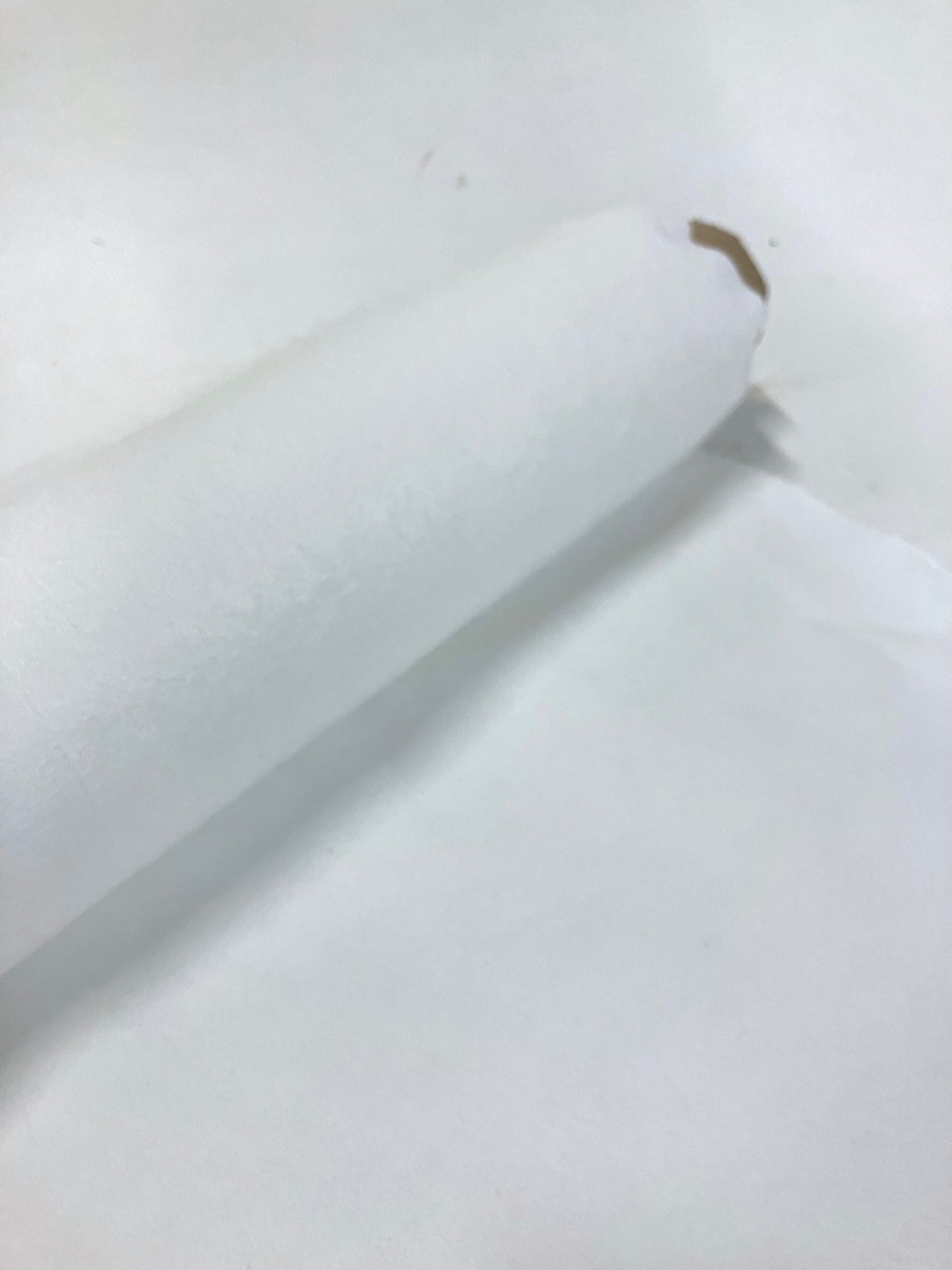 Roll of cellulosic felted fabric in white
