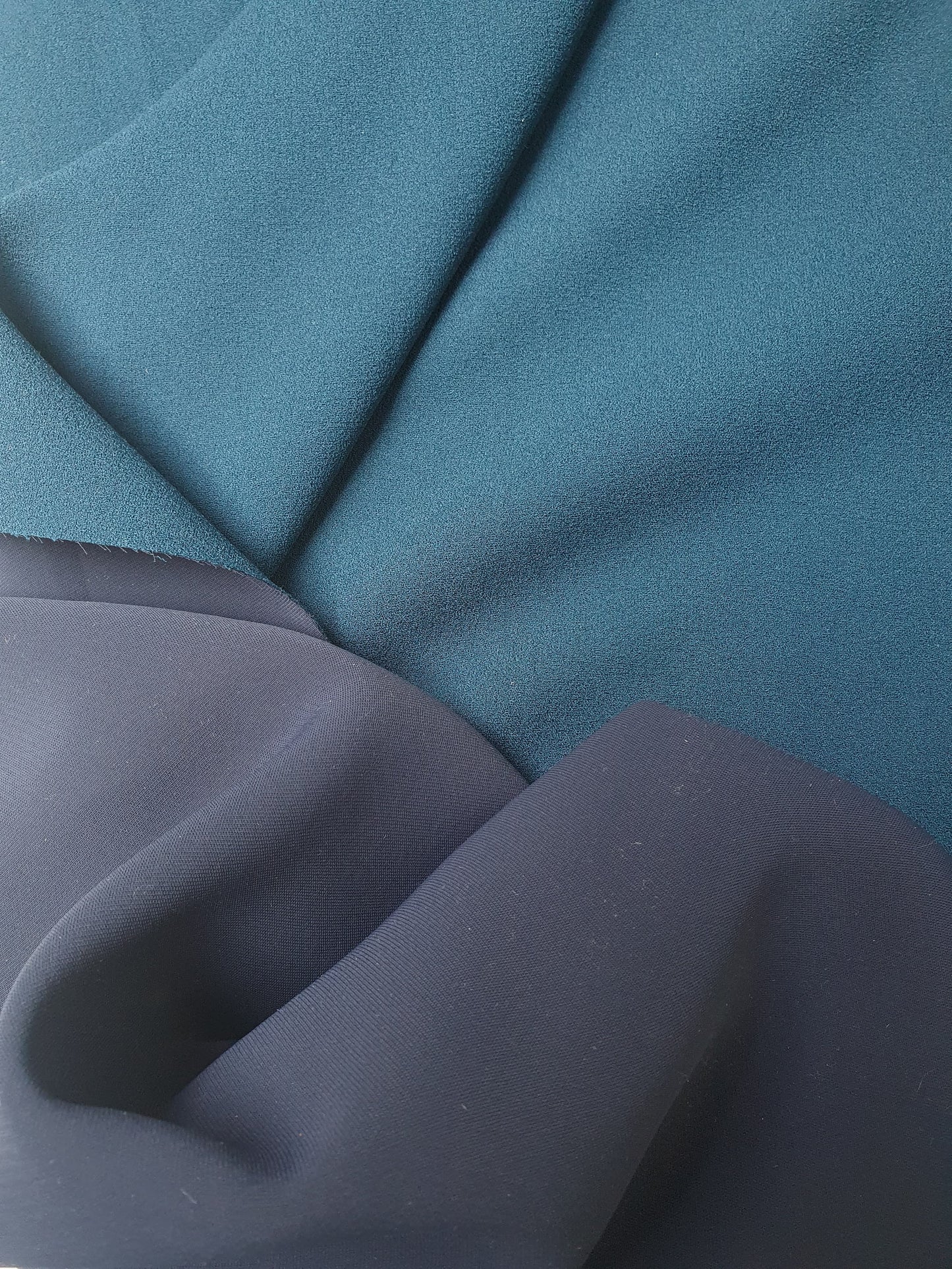 Close-up of heavy double-backed fabric in dark teal, soft texture visible 