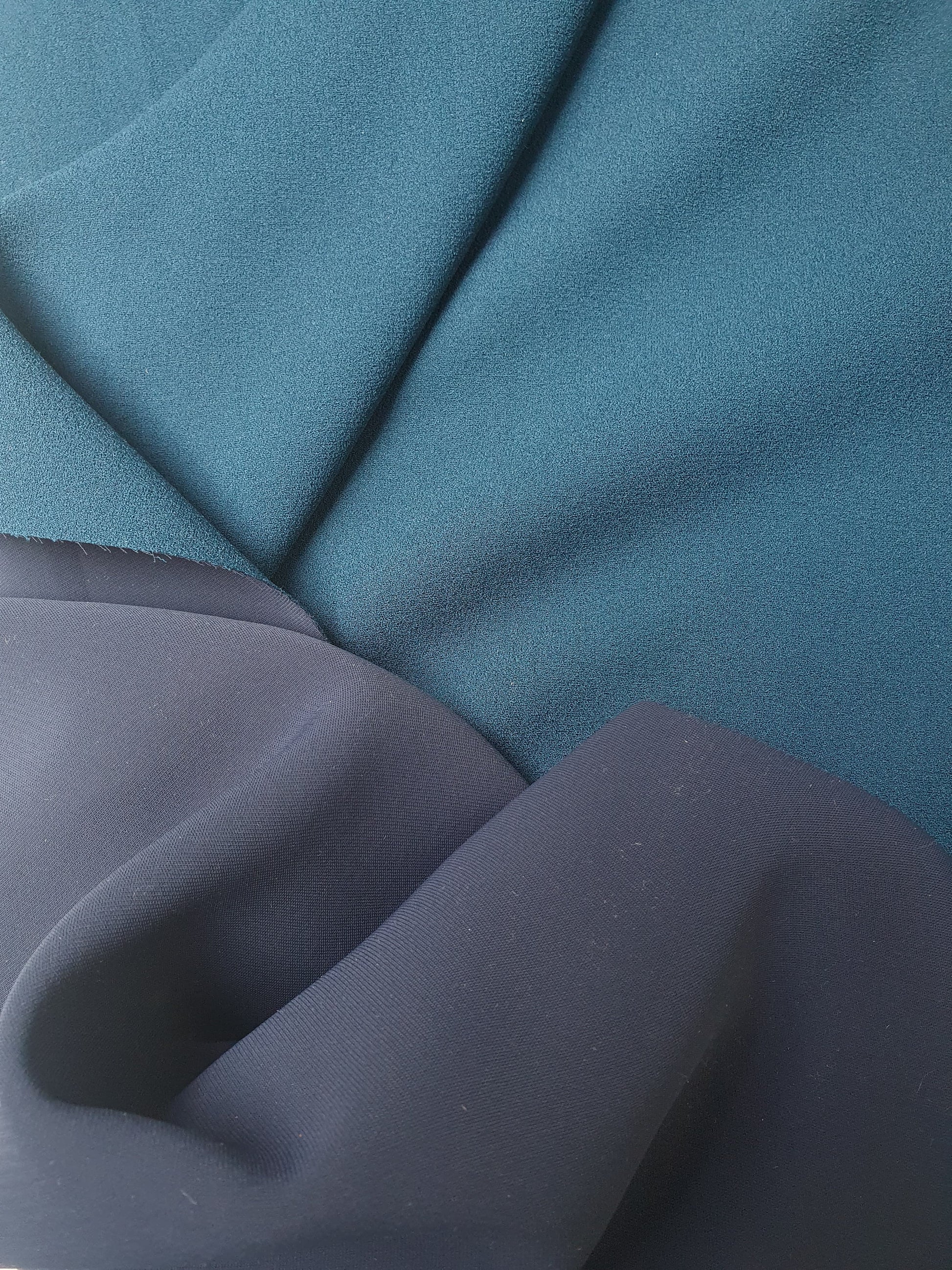 Close-up of heavy double-backed fabric in dark teal, soft texture visible 
