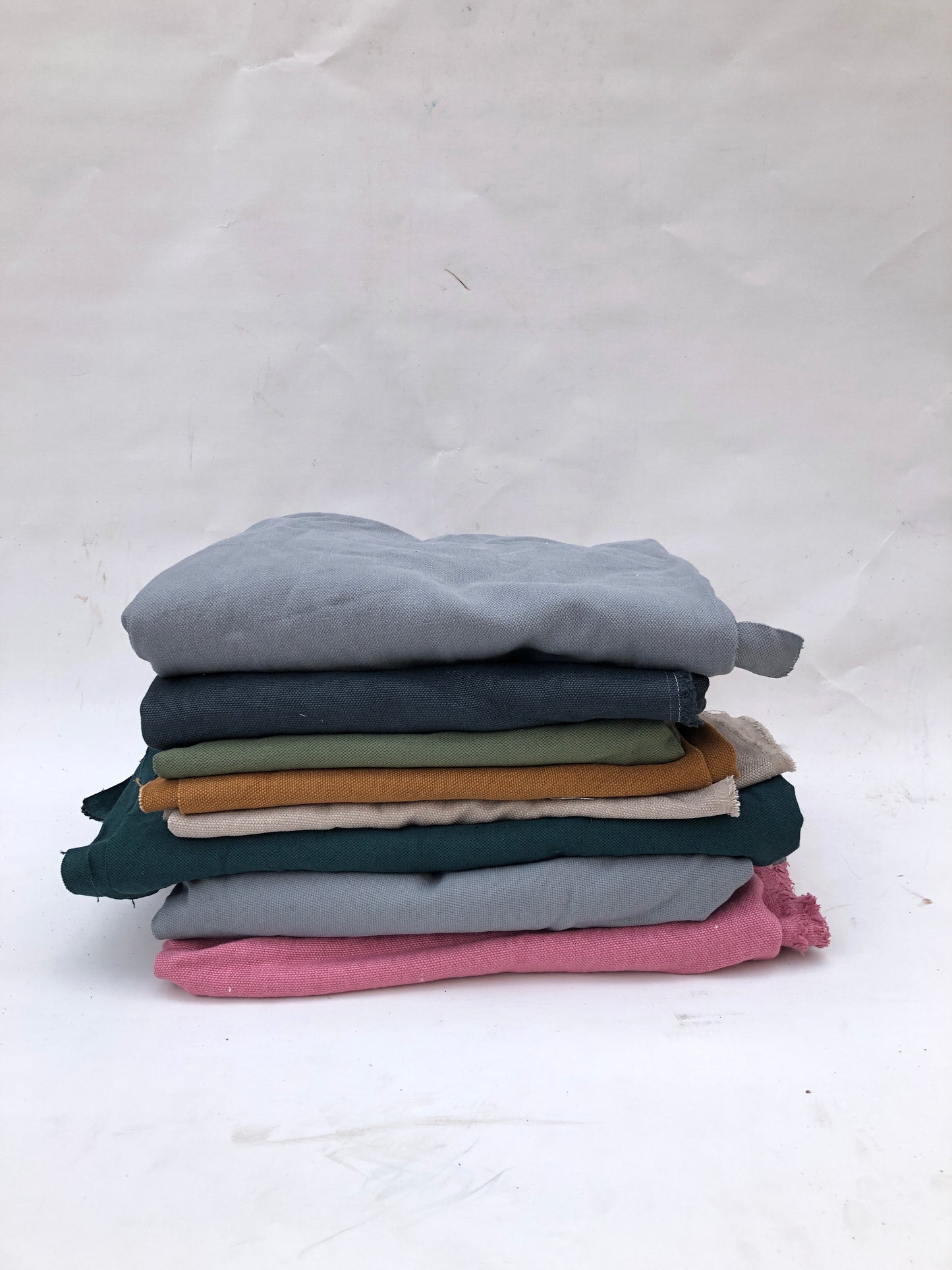 Stack of heavyweight linen fabric in various colours 