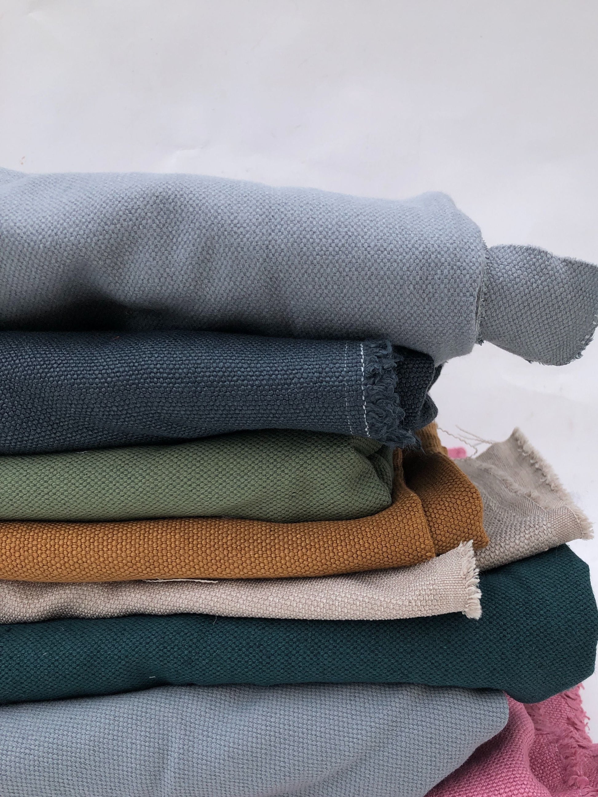 Stack of heavyweight linen fabric in various colours 
