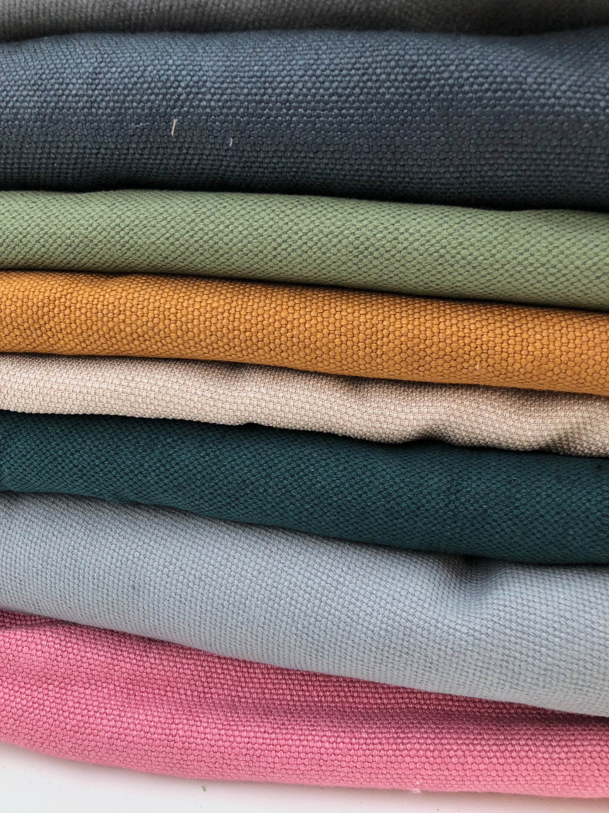 Stack of heavyweight linen fabric in various colours 