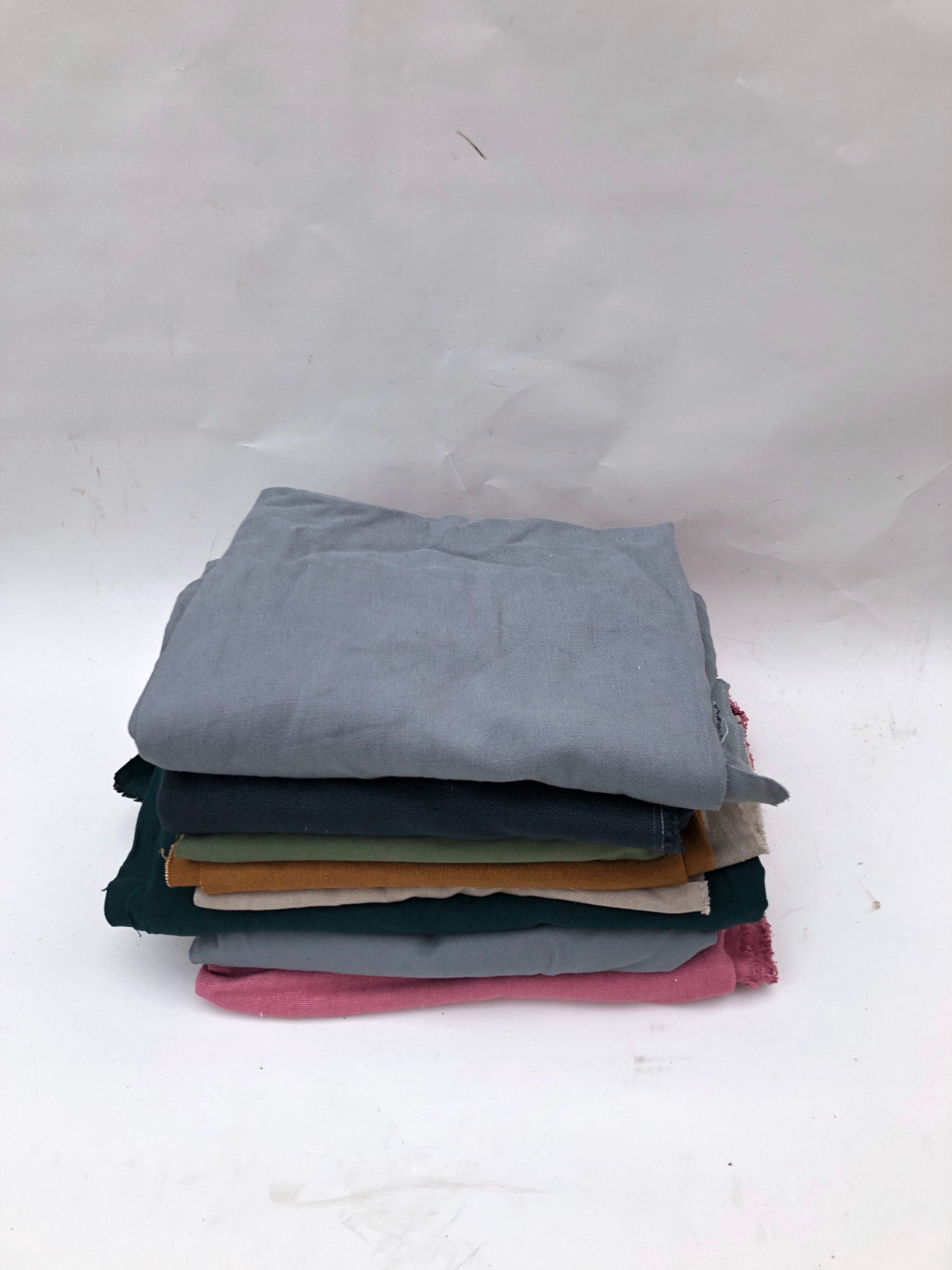 Stack of heavyweight linen fabric in various colours 