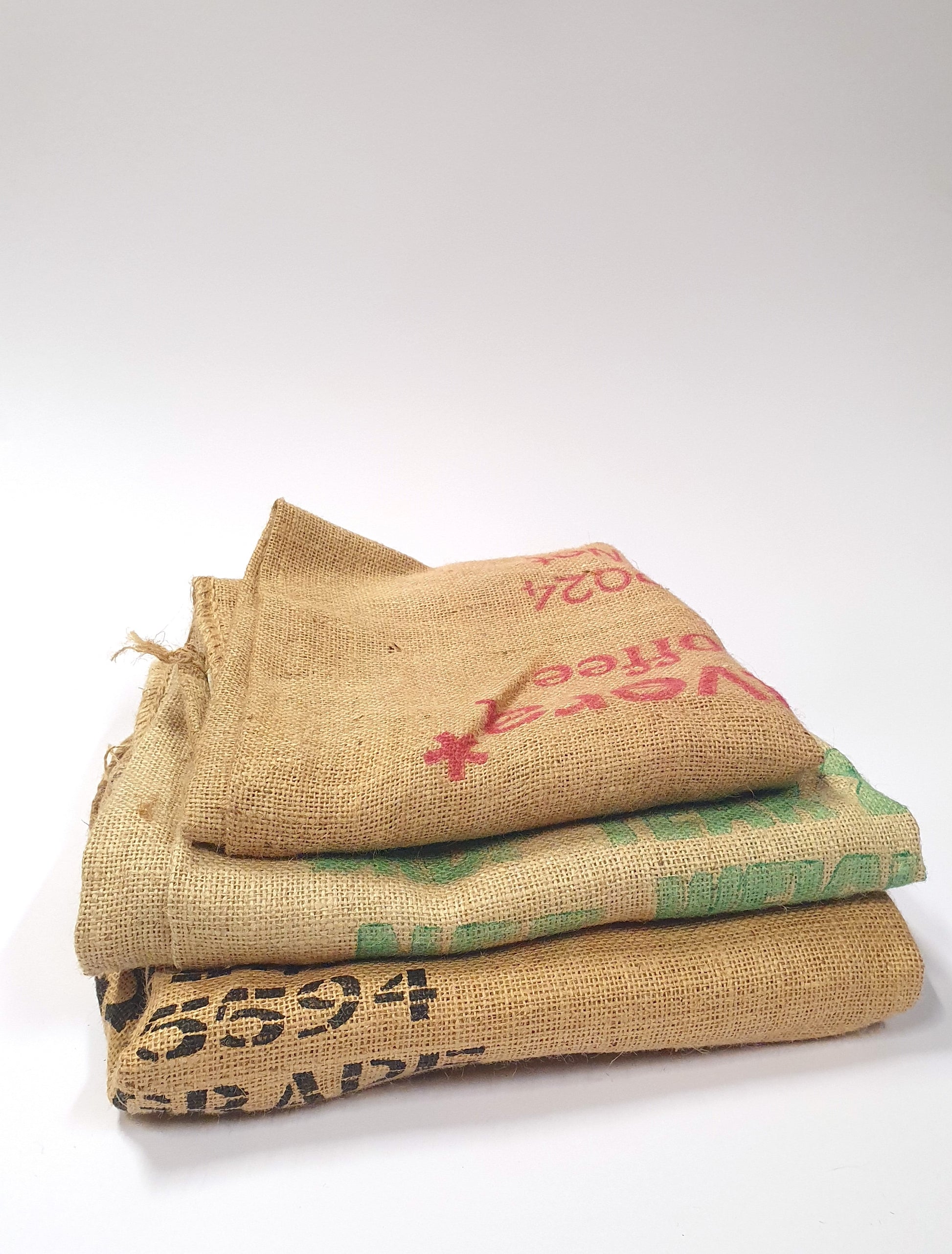 Stack of hessian fabric coffee jute sack with printed on designs and words