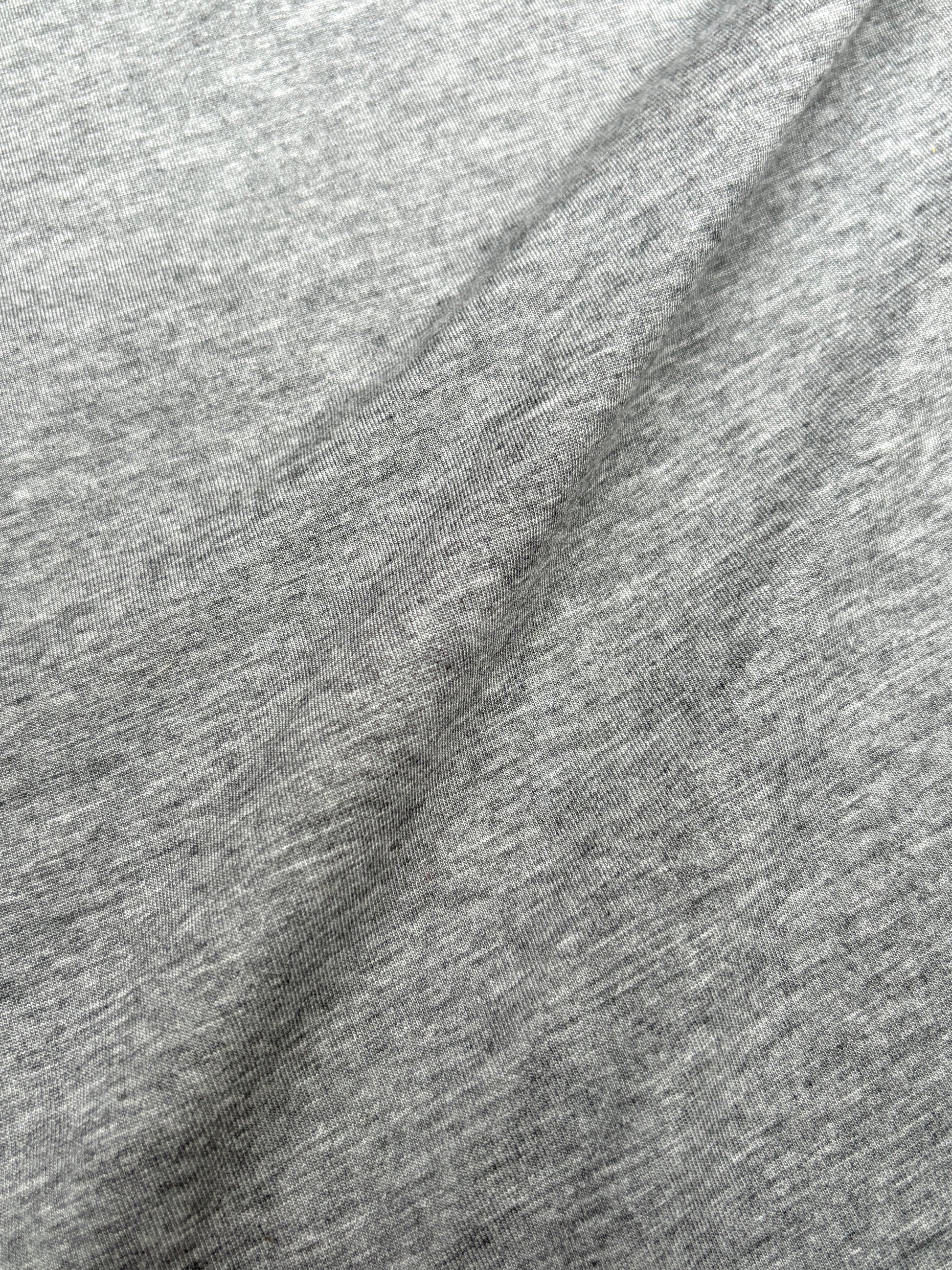 Close-up of light weighted jersey fabric in grey, soft texture visible 