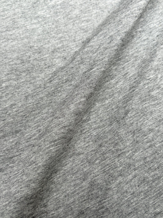 Close-up of light weighted jersey fabric in grey, soft texture visible 