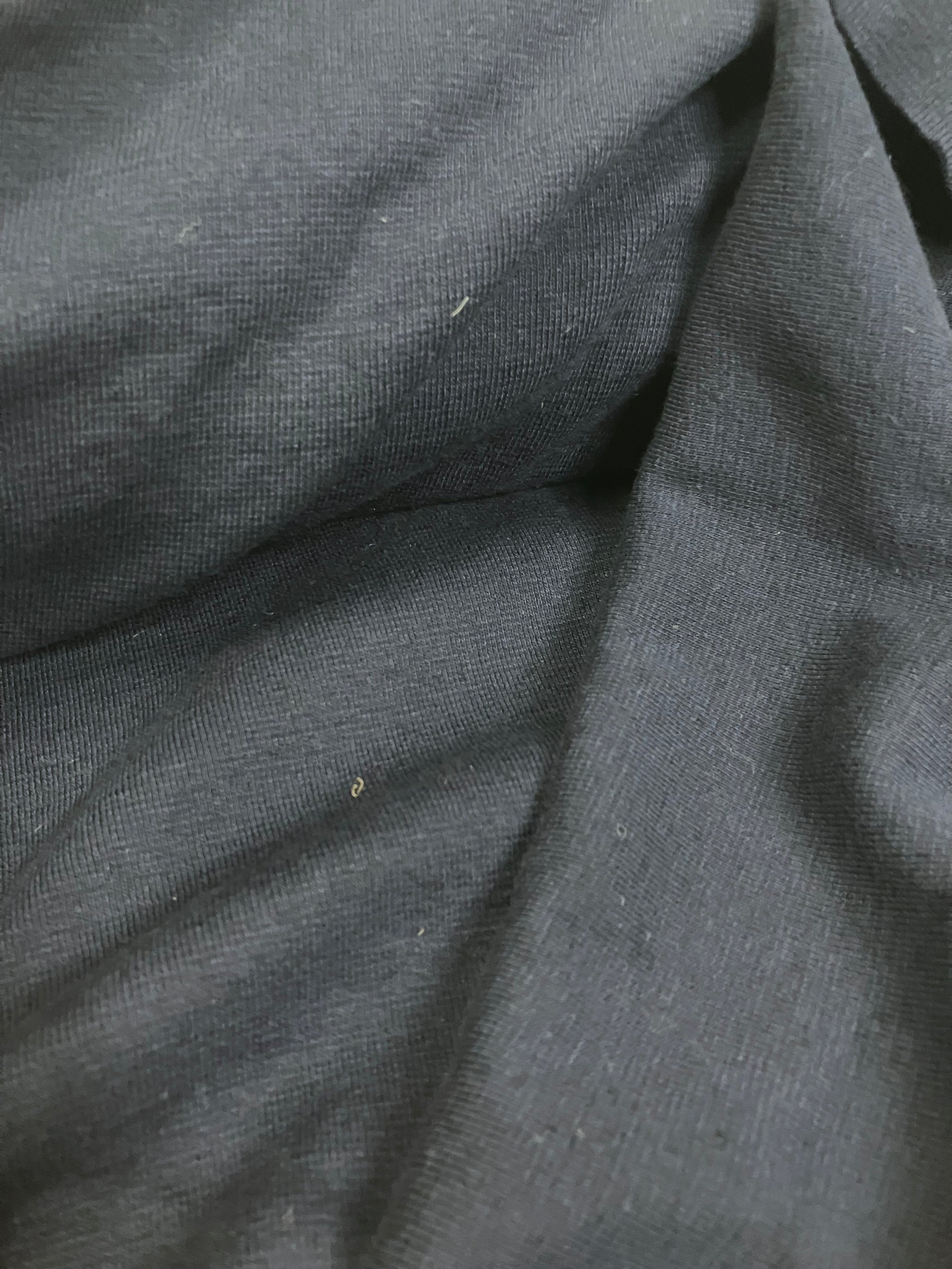 Close-up of light weighted jersey fabric in navy, soft texture visible 