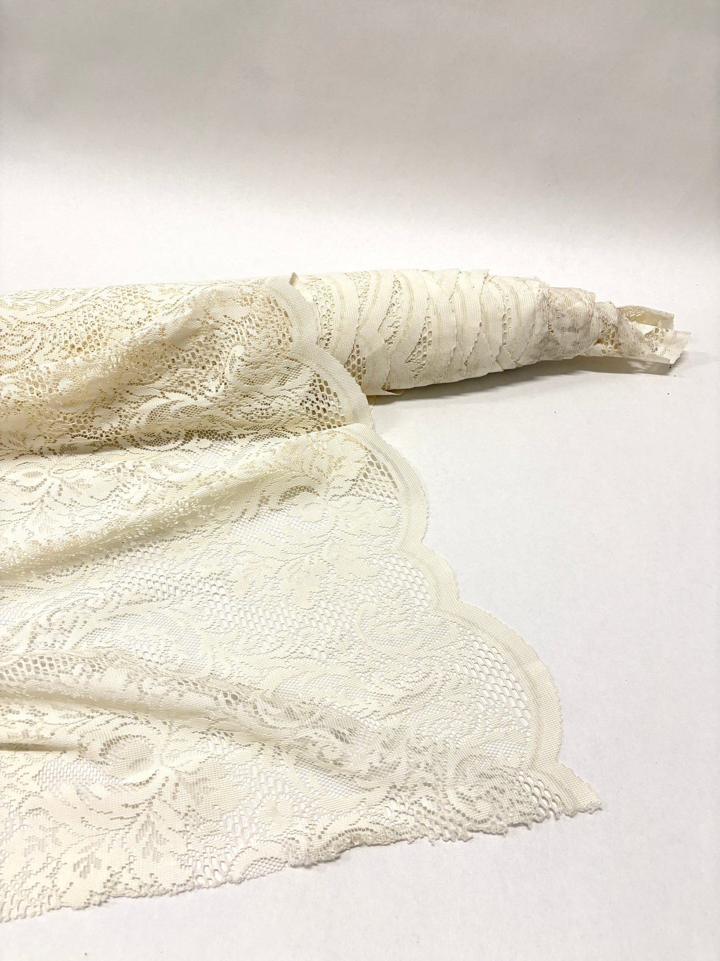 Roll of lace fabric in cream white 