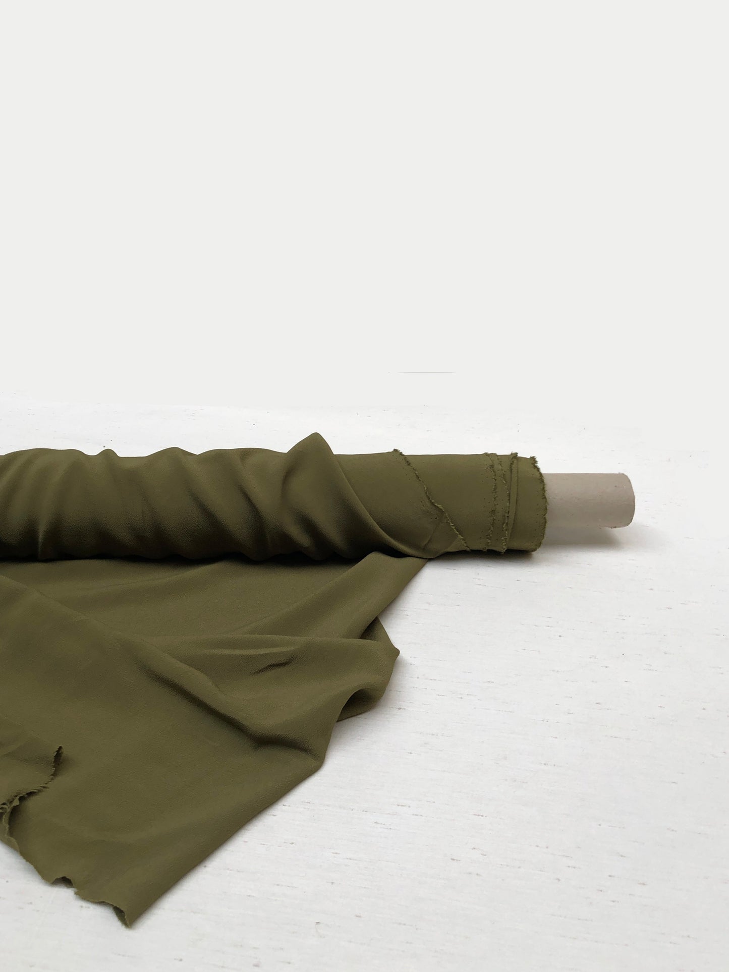 Roll of light weighted crape fabric in olive green 