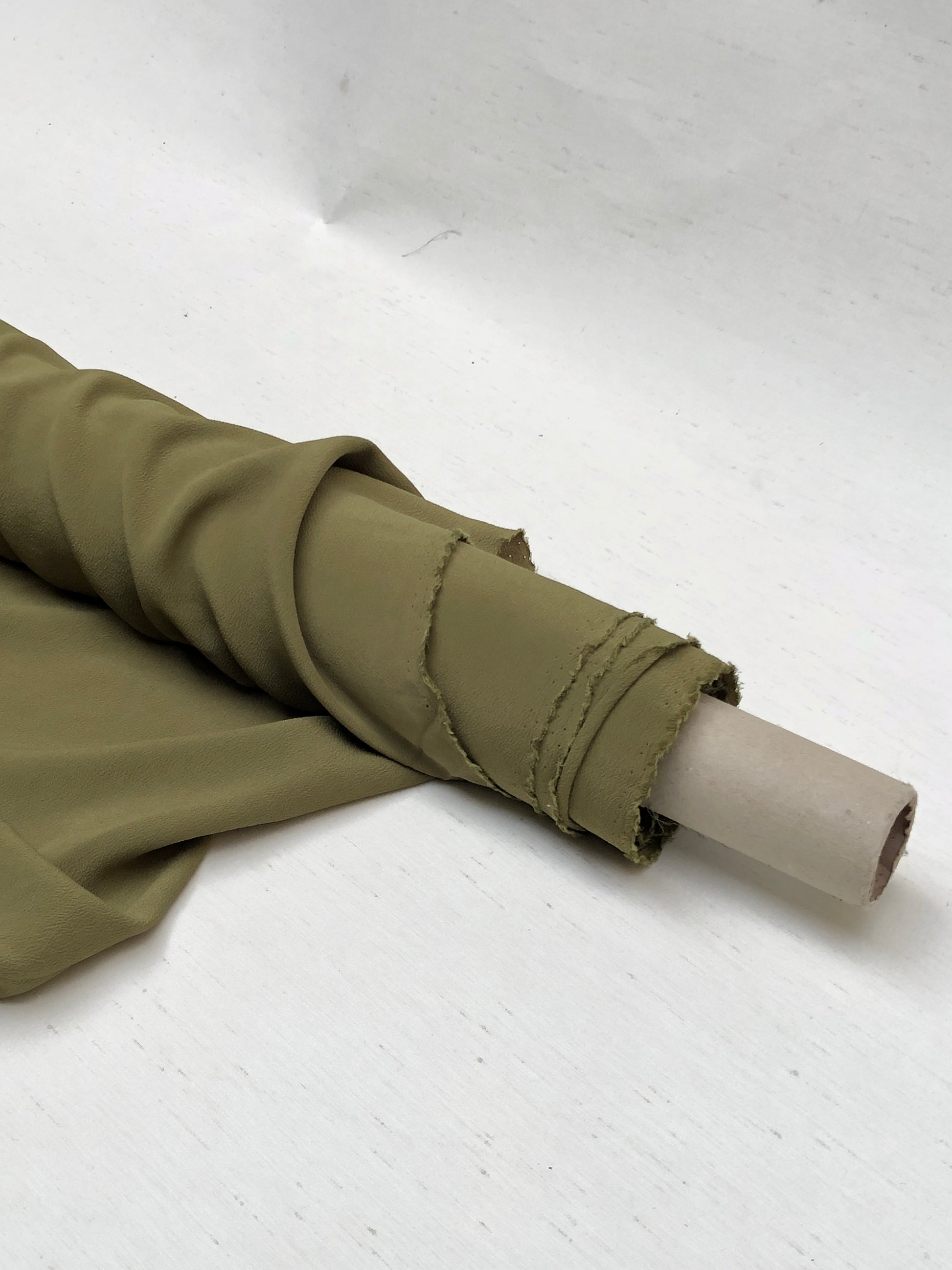 Roll of light weighted crape fabric in olive green 