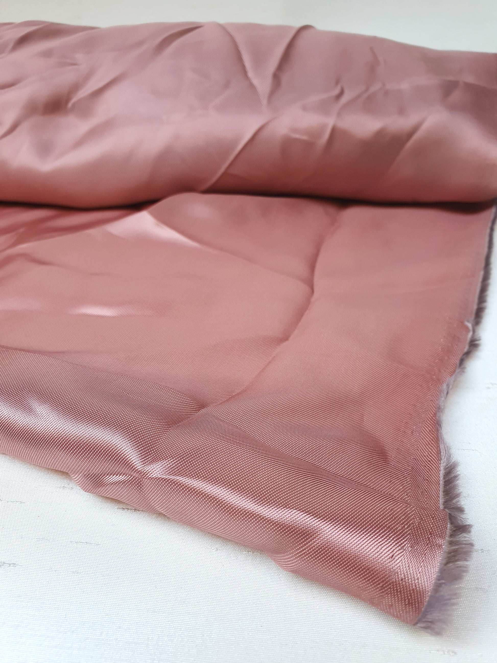 Satin twill fabric in pink, shiny texture visible 
