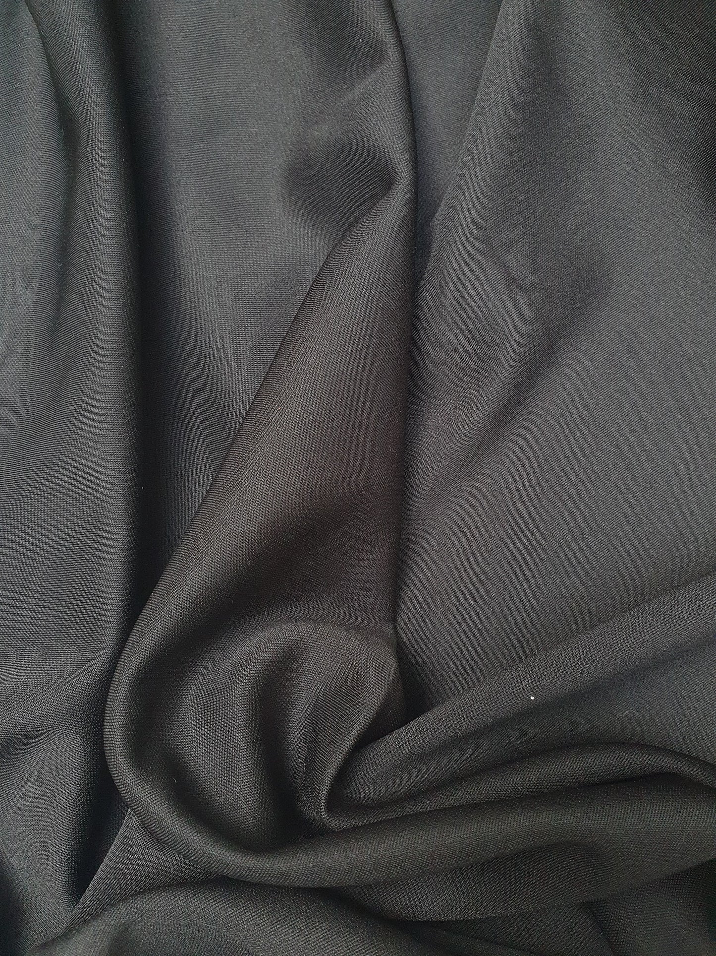 Close-up of lycra spandex fabric in black, shiny texture visible 