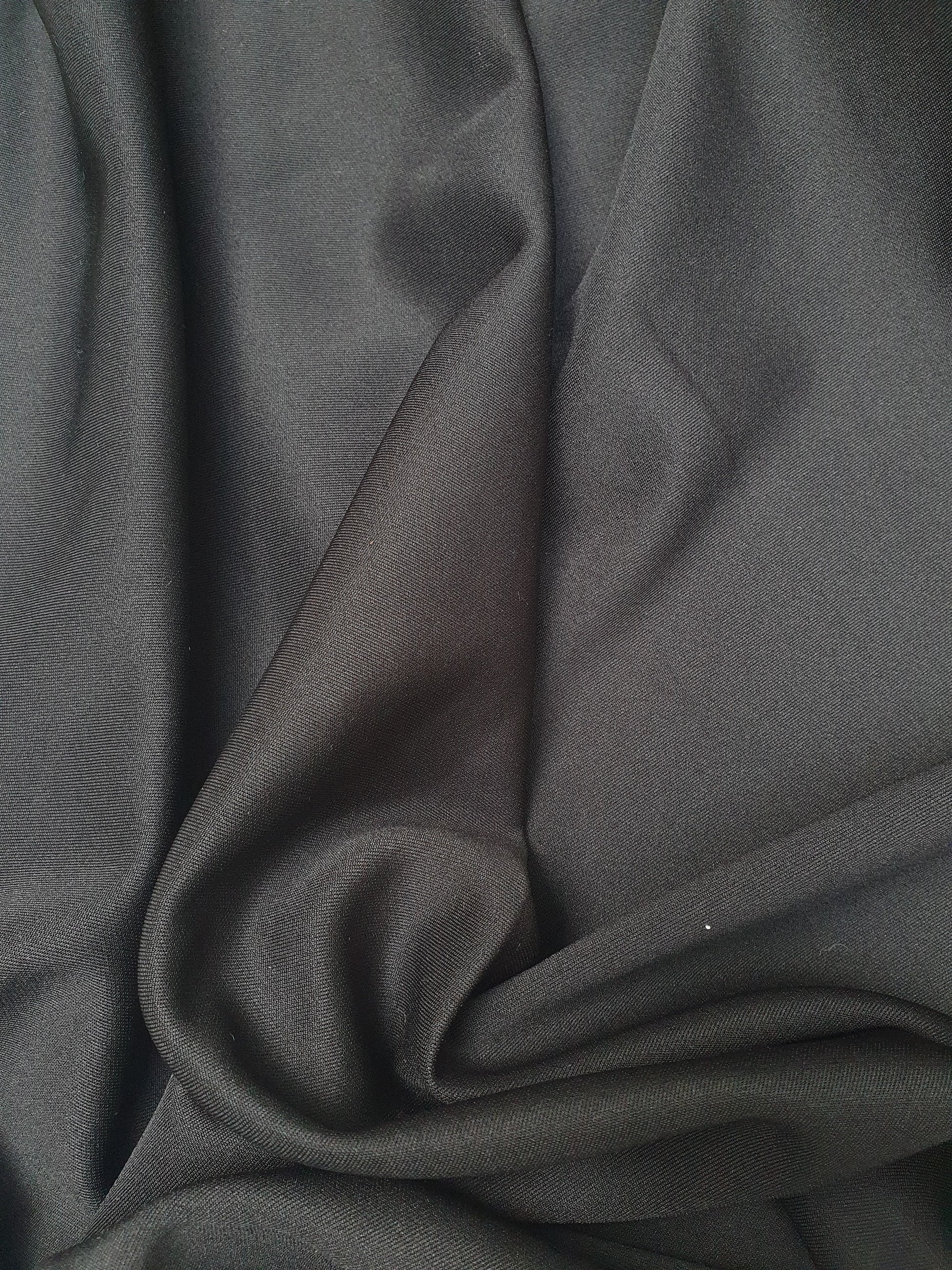 Close-up of lycra spandex fabric in black, shiny texture visible 
