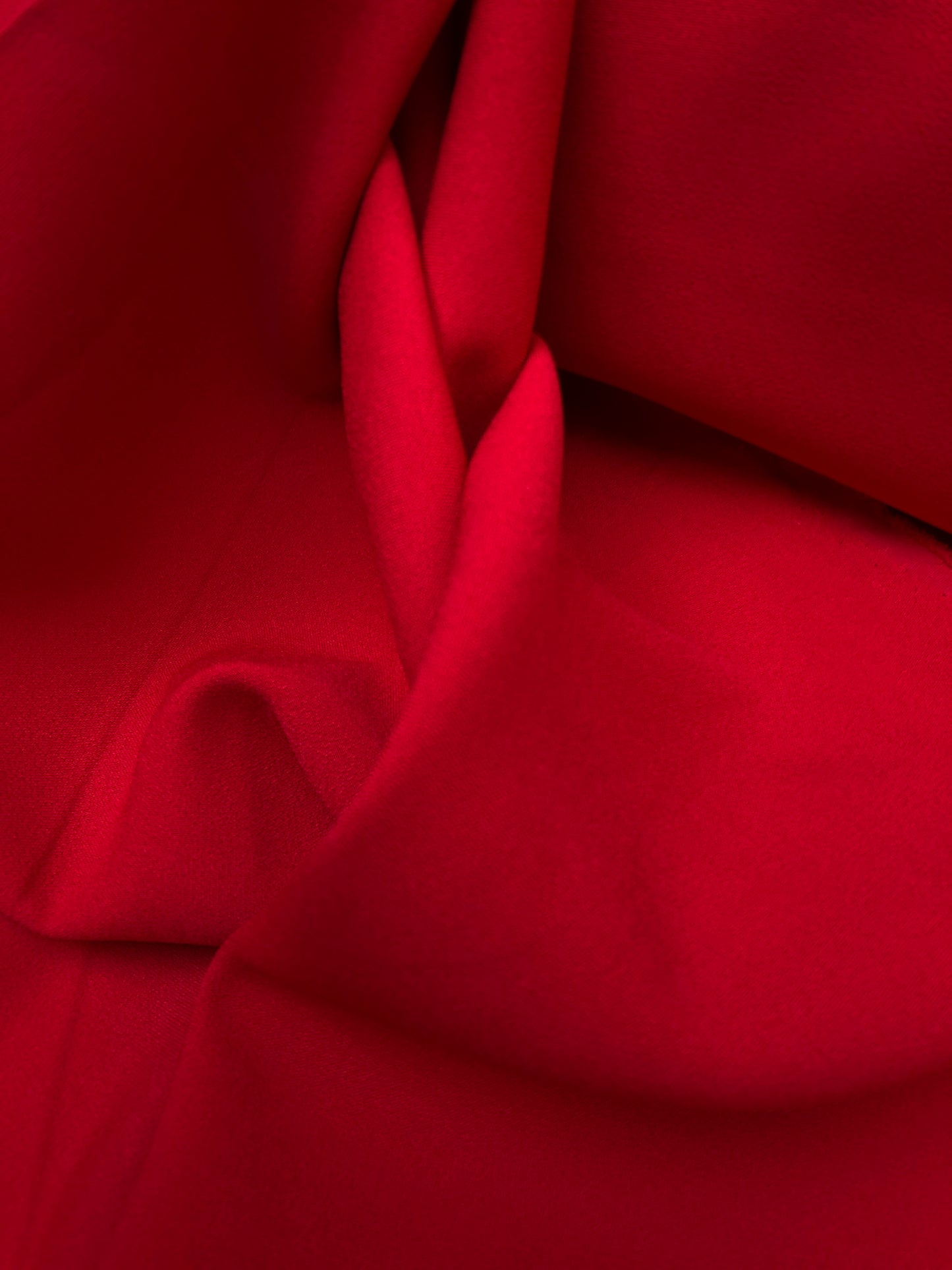 Close-up of hopsack fabric in red, shiny texture visible 