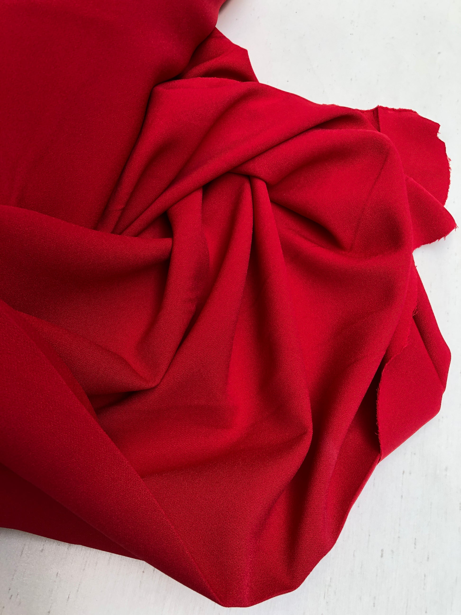 Close-up of hopsack fabric in red, shiny texture visible 
