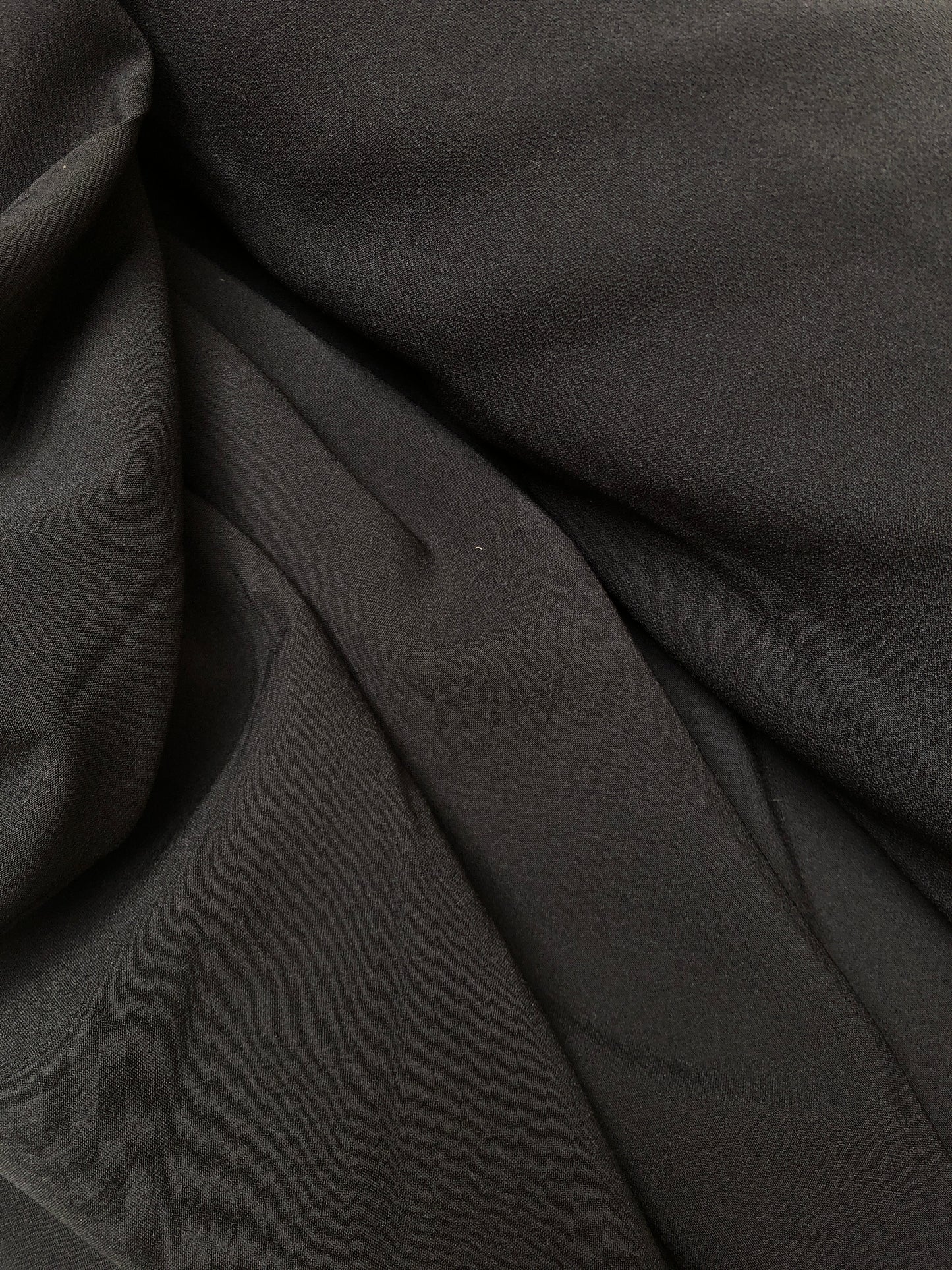 Close-up of hopsack fabric in black, shiny texture visible 