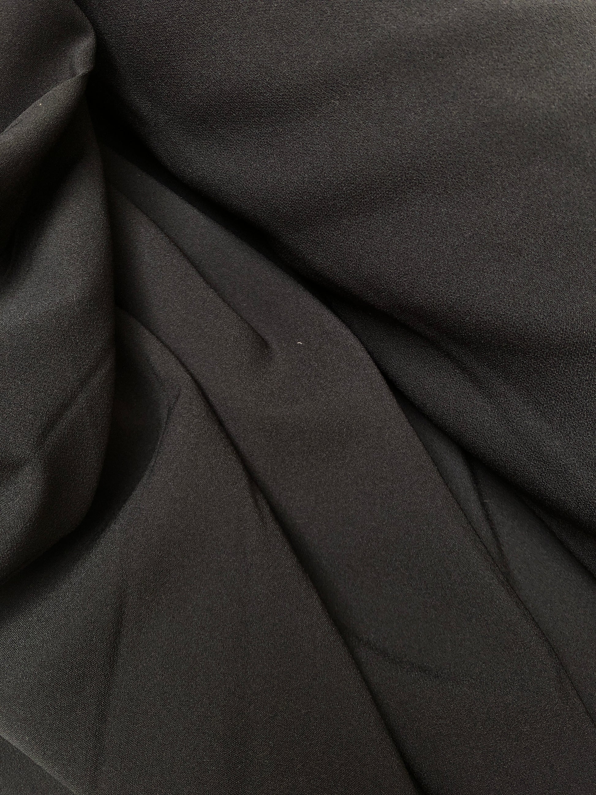 Close-up of hopsack fabric in black, shiny texture visible 