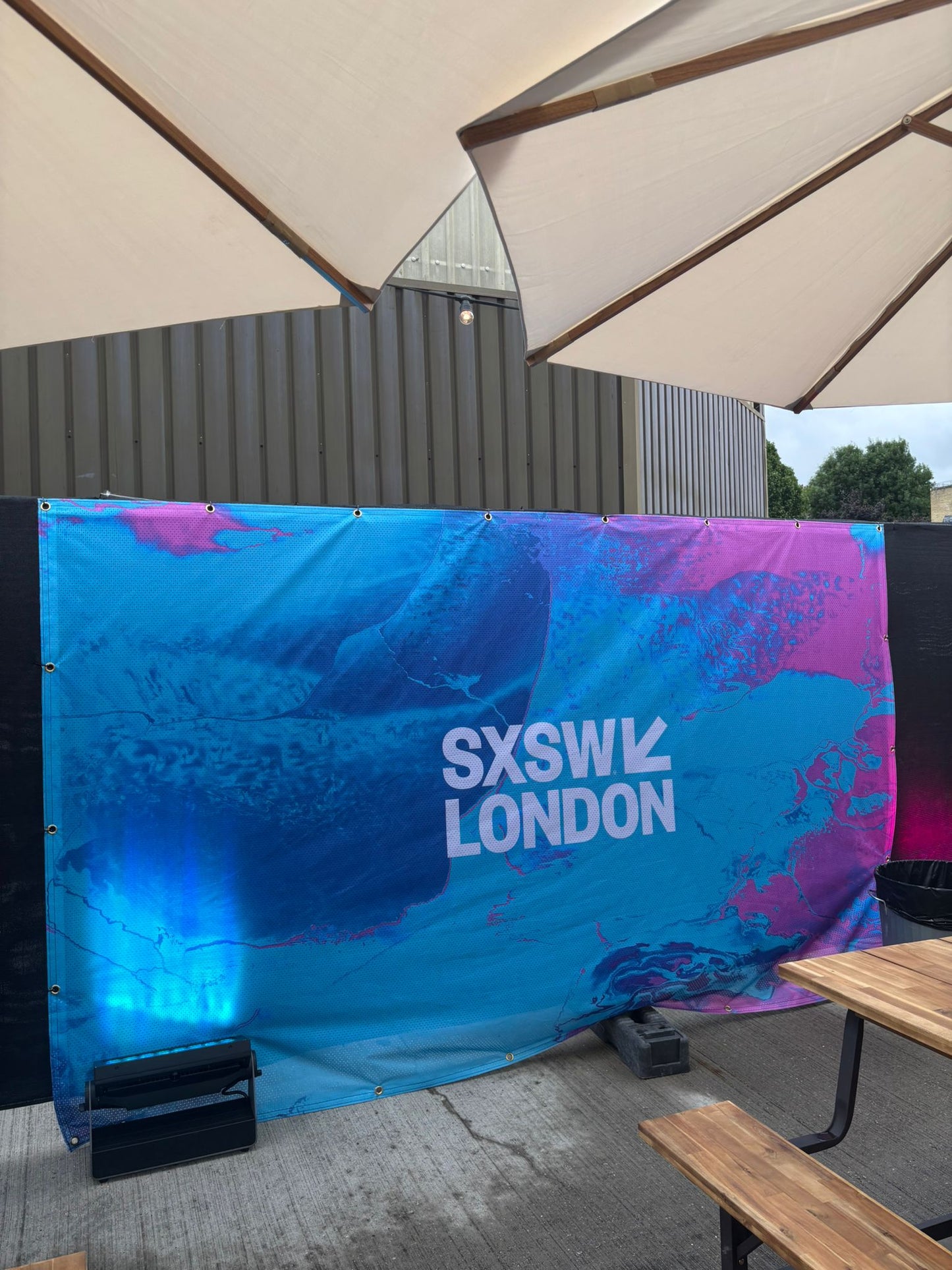 Fabric banner reading SXSW London with blue and pink design 