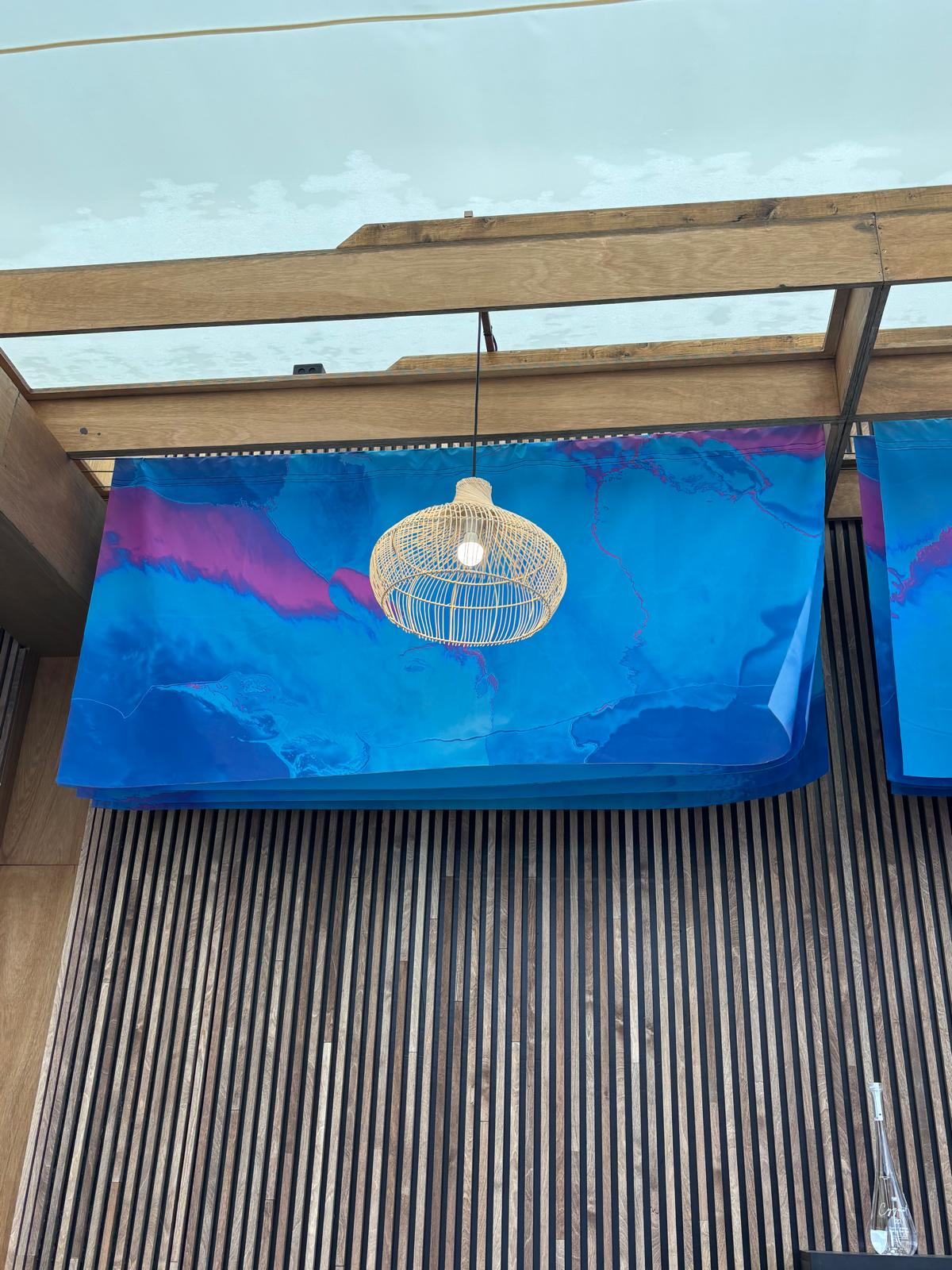 Blue fabric banner hung from a sealing 