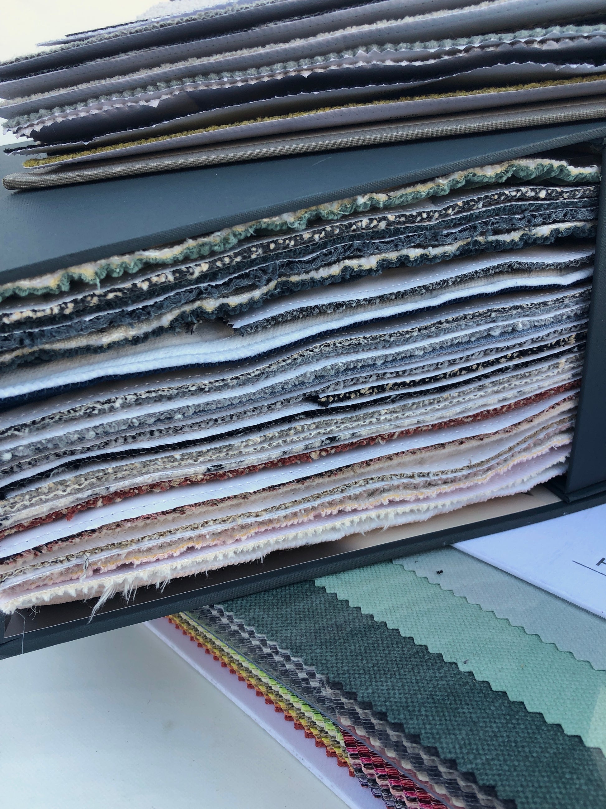 Collection of fabric sample books in various colours and textures 