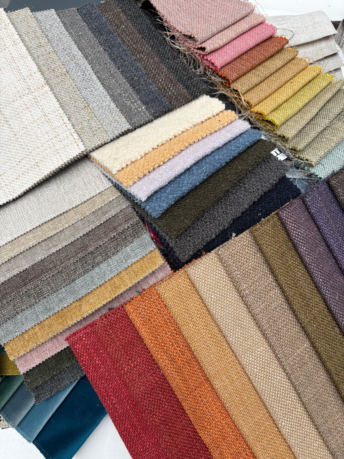 Open sample folders display woven and velvet fabric swatches in detail