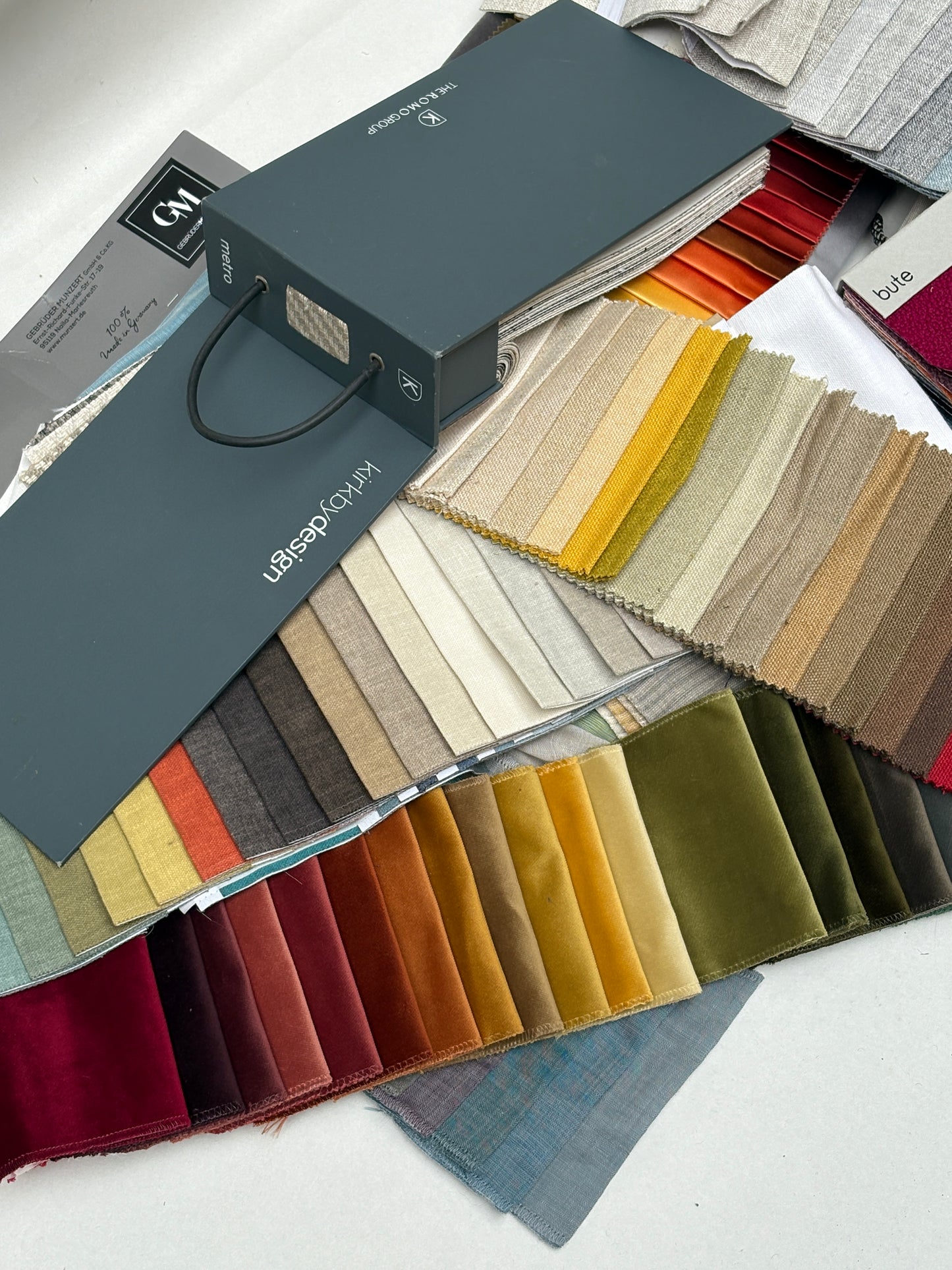 Fabric sample books are opened to show colour and texture swatches