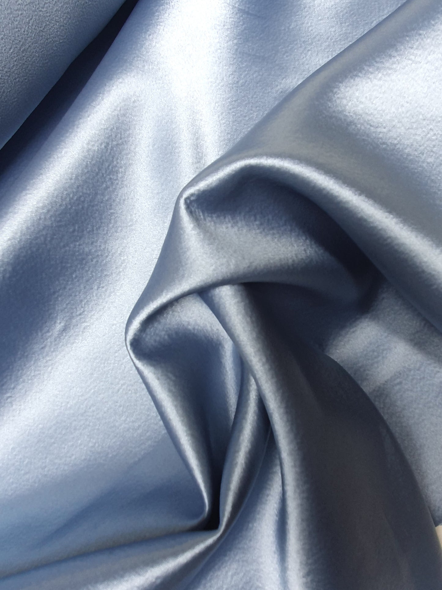 Close-up of satin crepe double cloth fabric in baby blue