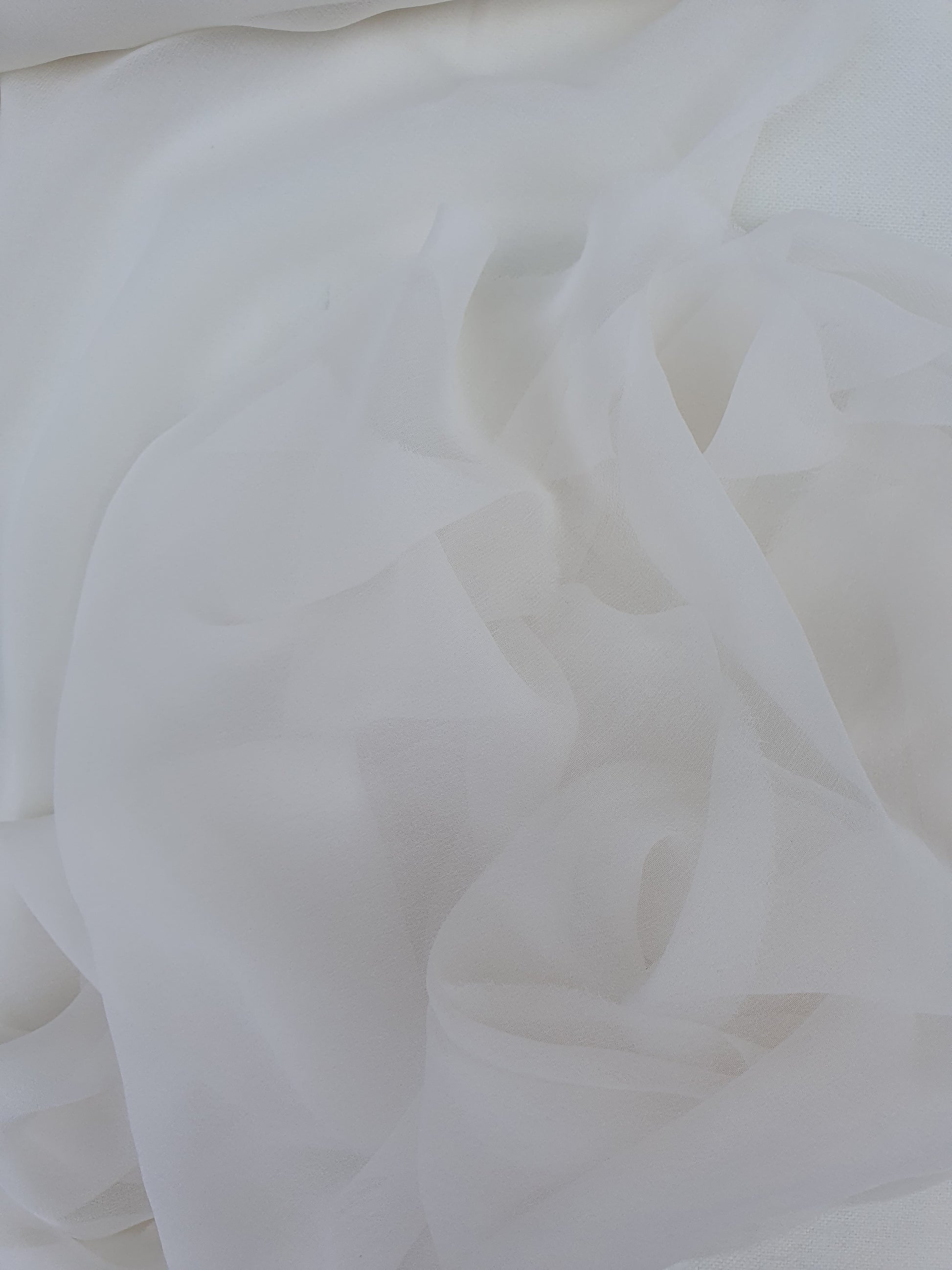 A close-up of translucent white silk organza fabric