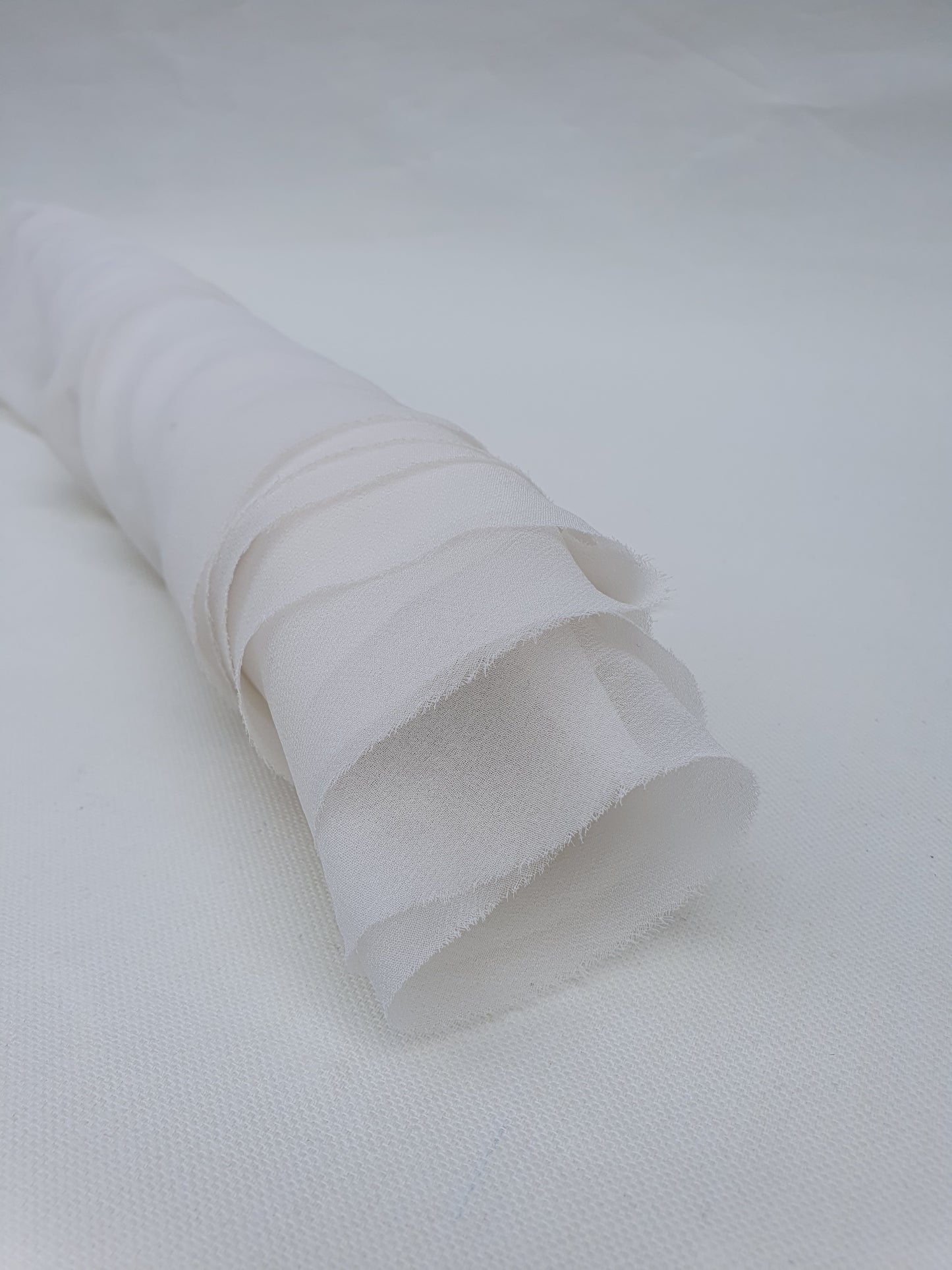 A close-up of translucent white silk organza fabric