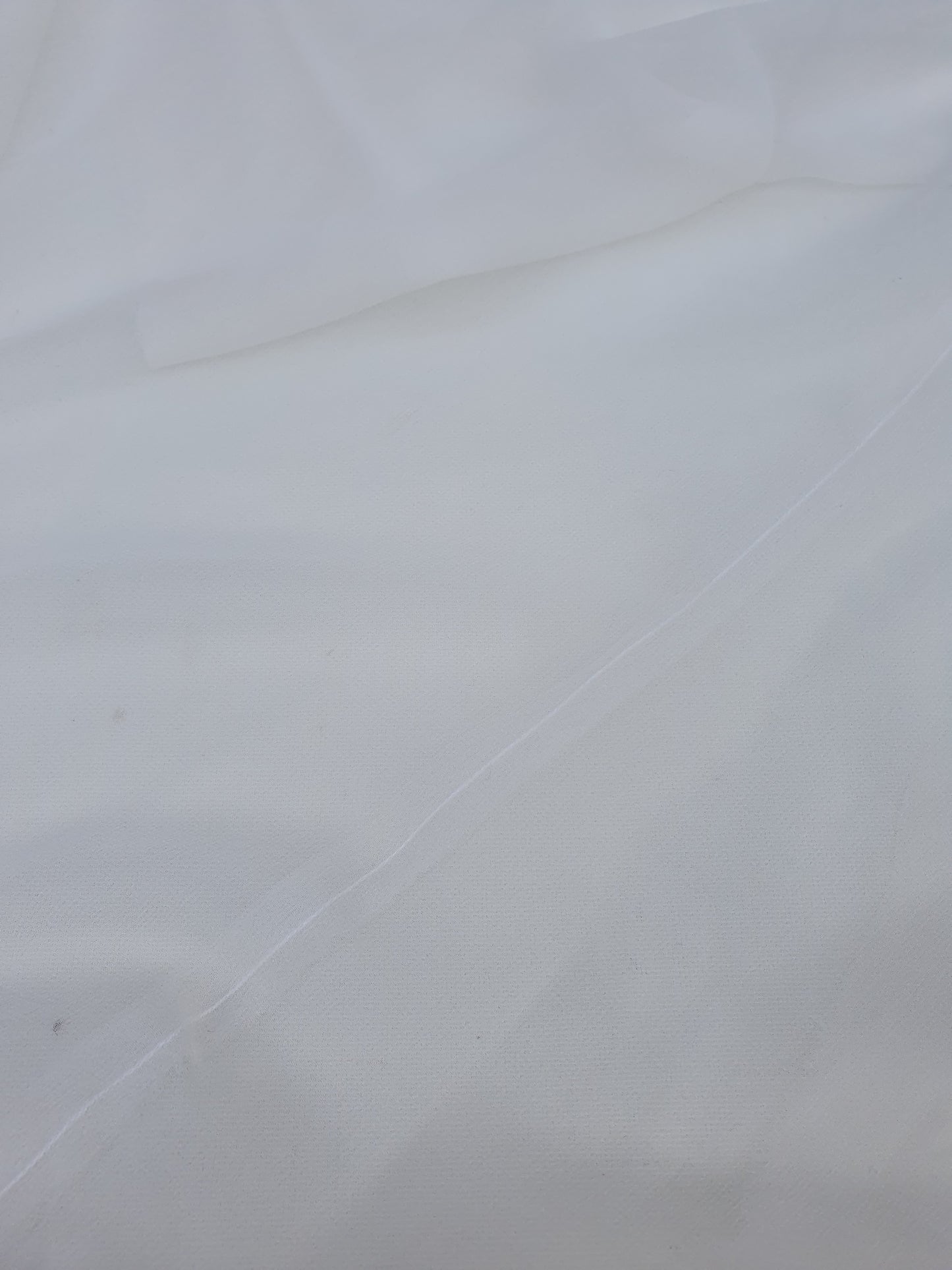 A close-up of translucent white silk organza fabric
