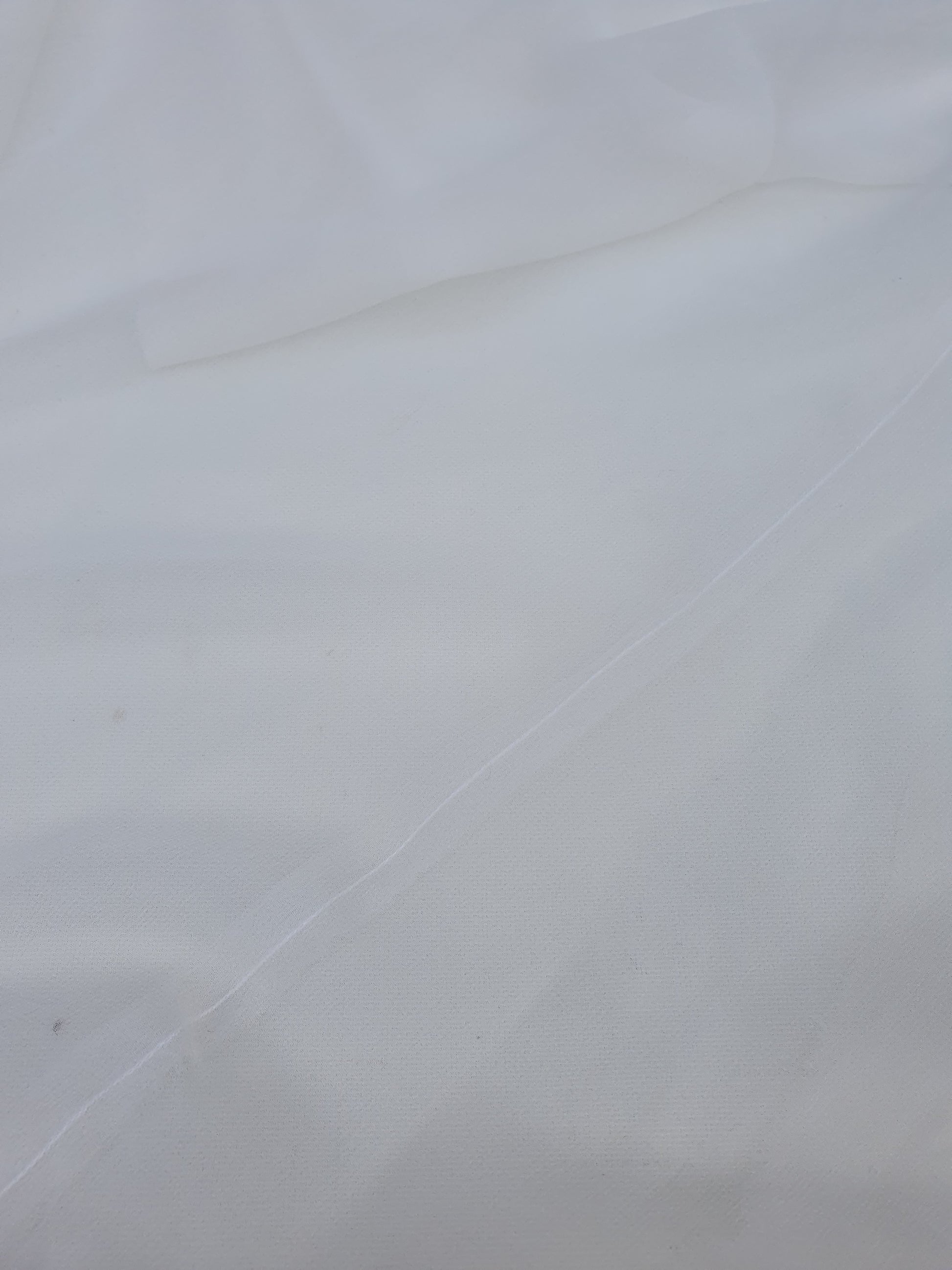A close-up of translucent white silk organza fabric