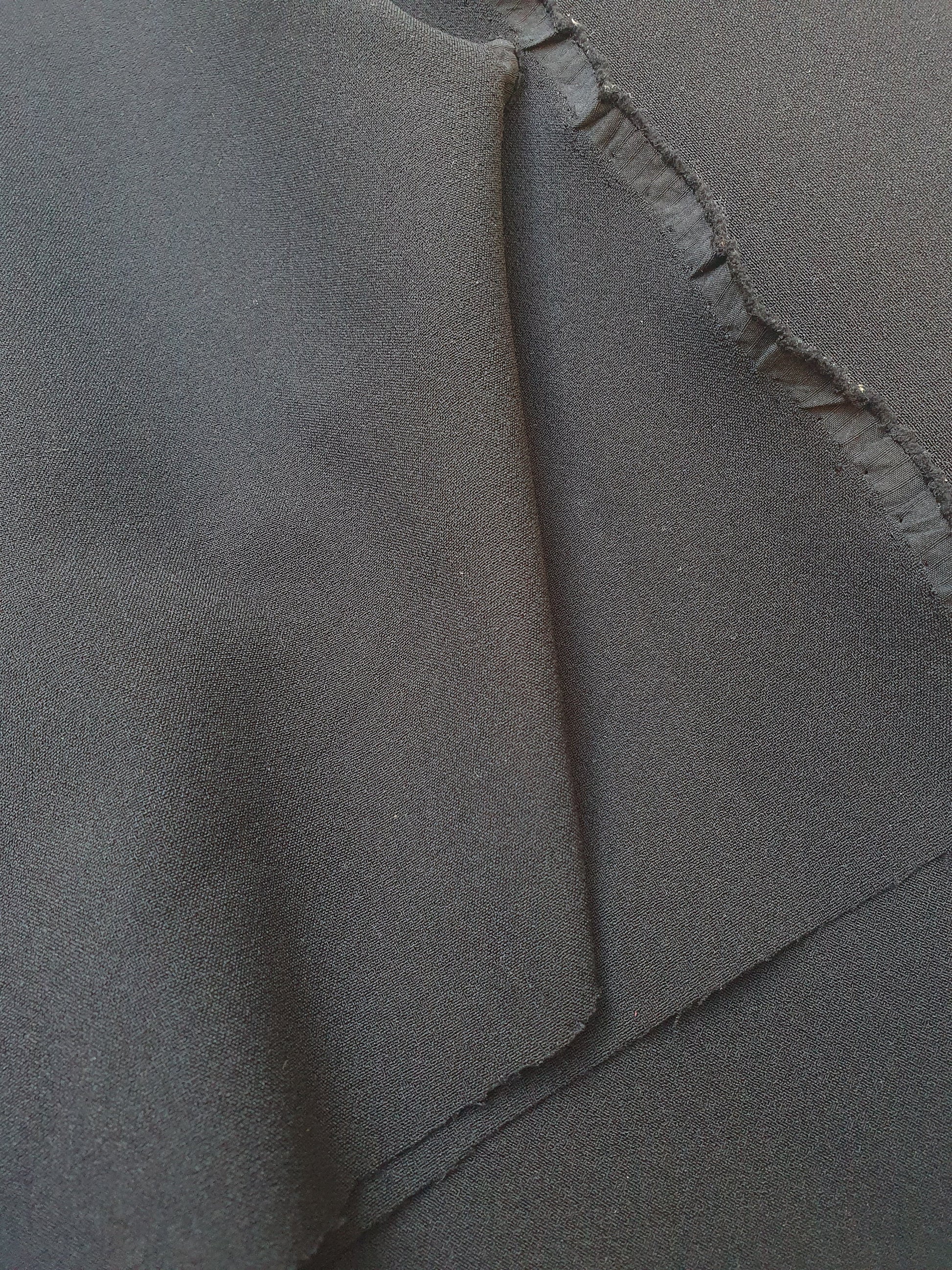 Close-up of stretch crepe fabric in black  with soft texture 
