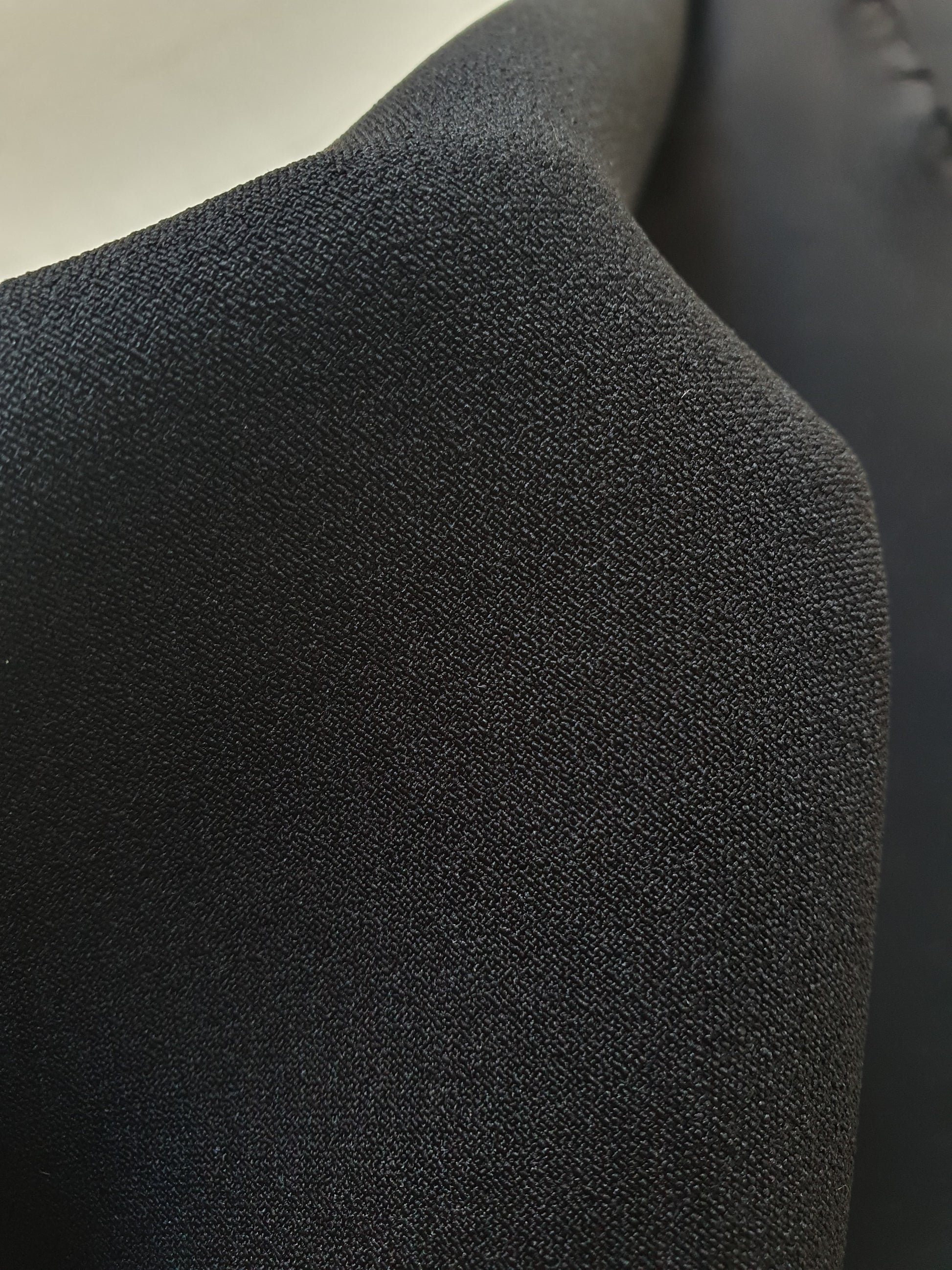 Close-up of stretch crepe fabric in black with soft texture 