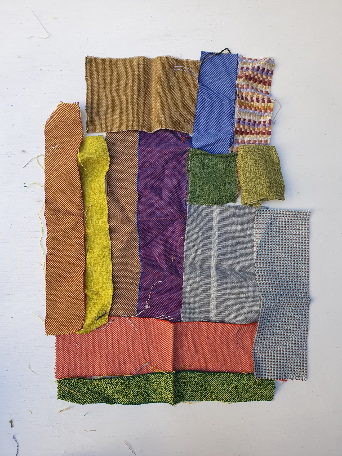 Various rectangular fabric offcuts in different colours and textures.