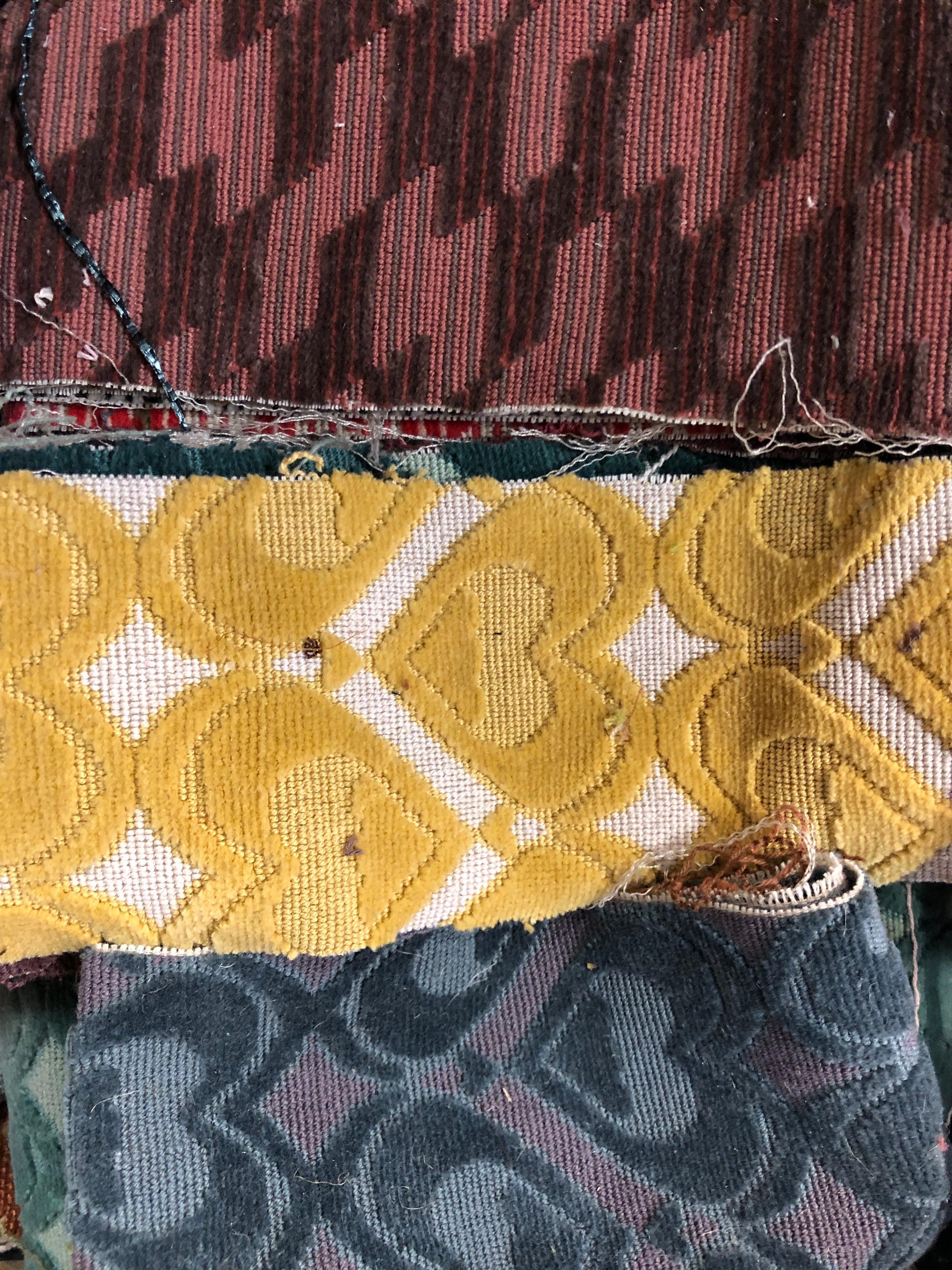 A pile of various rectangular fabric offcuts in different colours and textures.