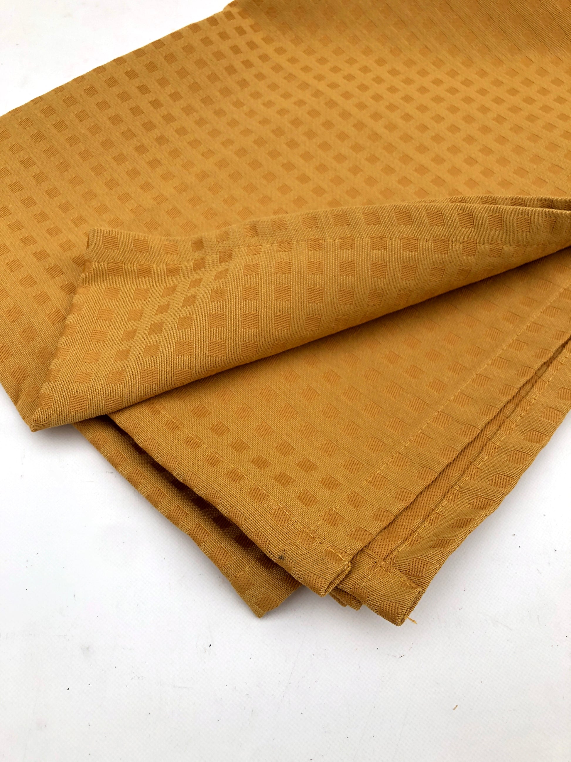 Table runner fabric in mustard yellow with chequered patterns