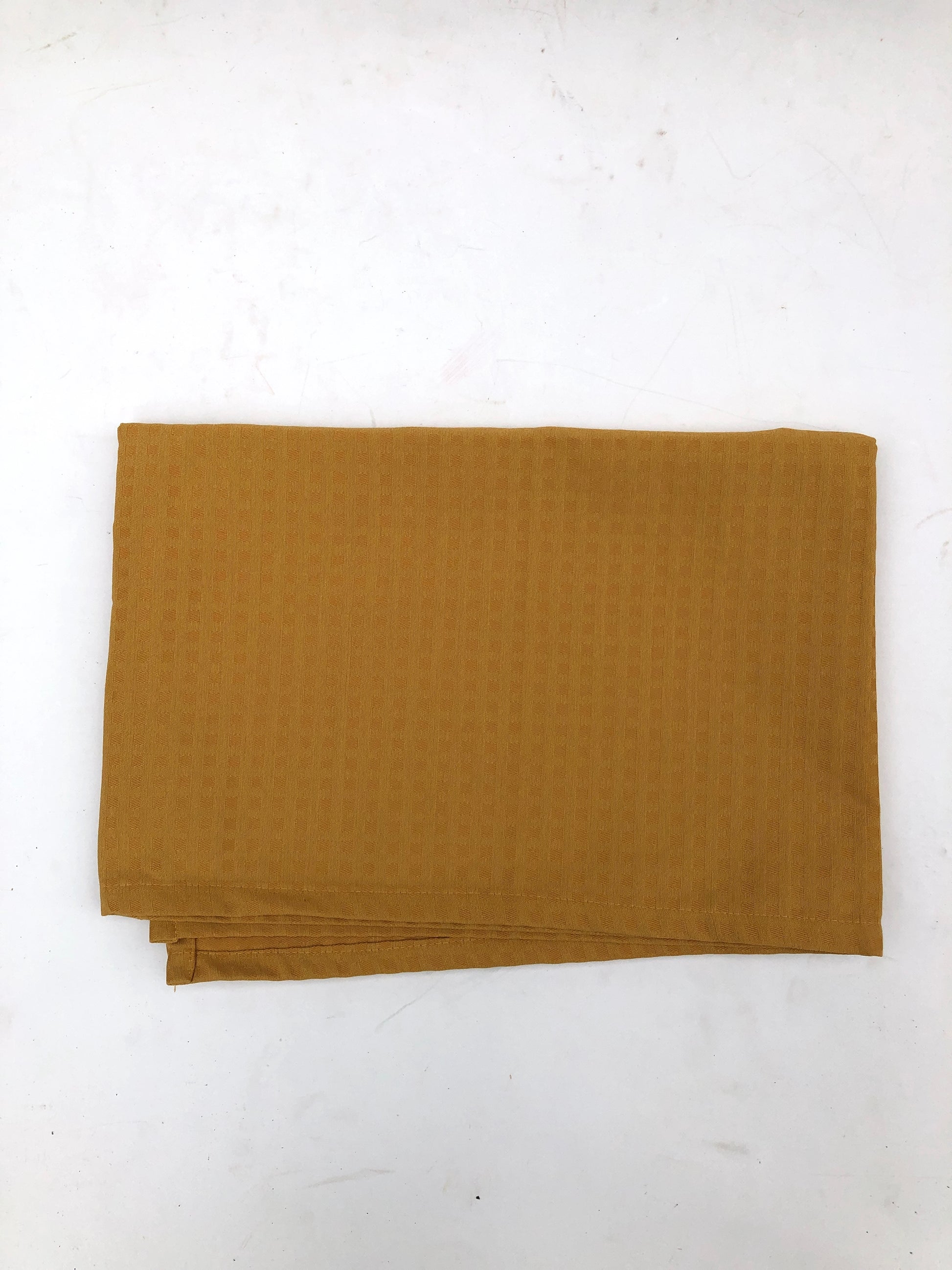 Folded table runner fabric in mustard yellow 