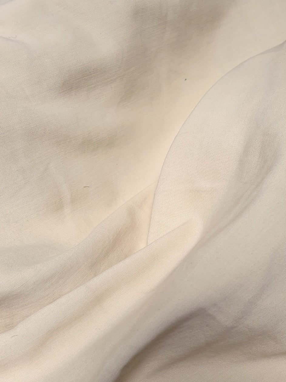 Close-up of a yellow-cream medium-weight taffeta fabric with a soft textured 