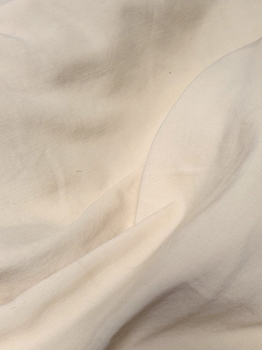 Close-up of a yellow-cream medium-weight taffeta fabric with a soft textured 